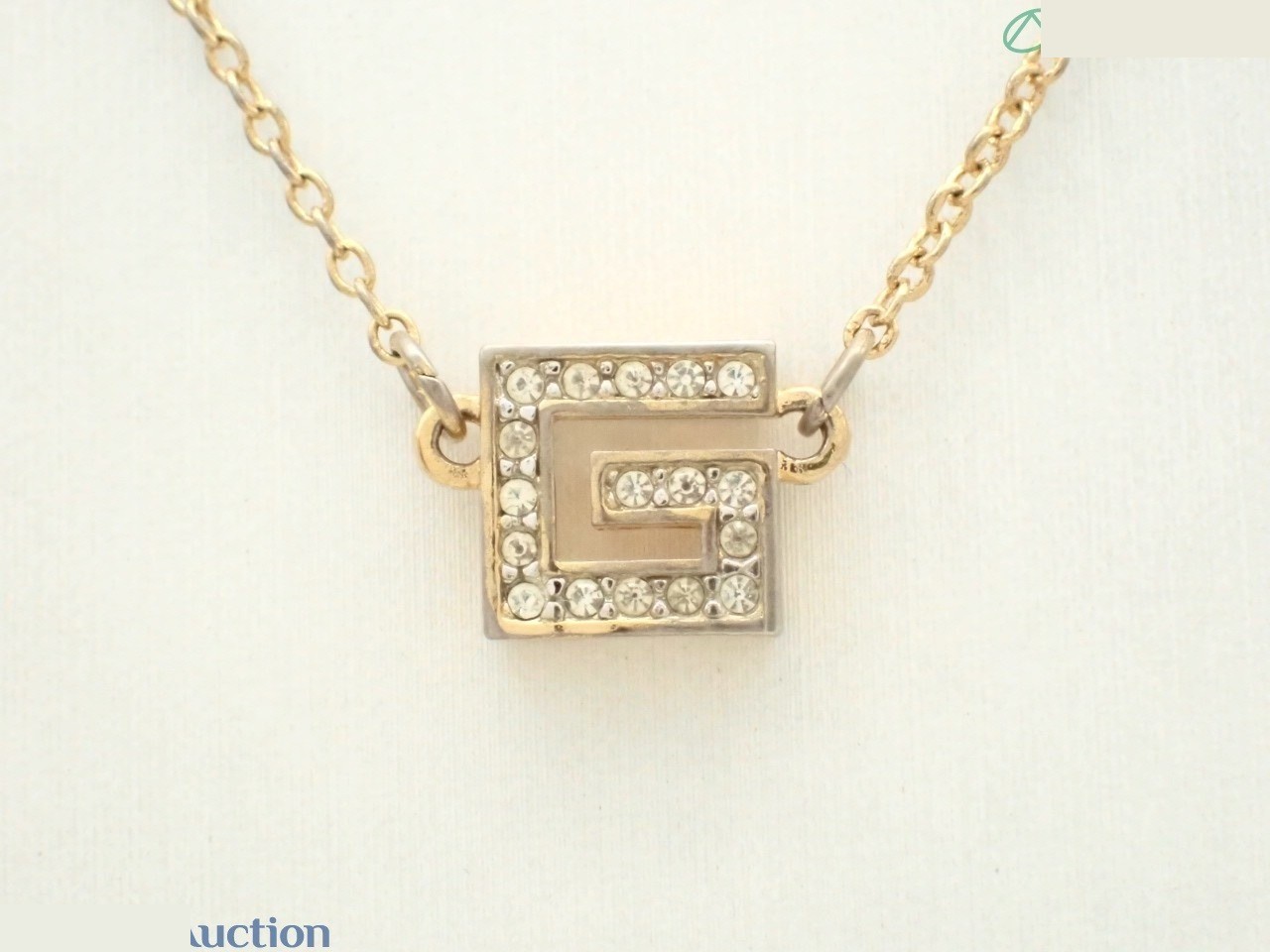 precious metal necklace/pendant, G logo, gold color.