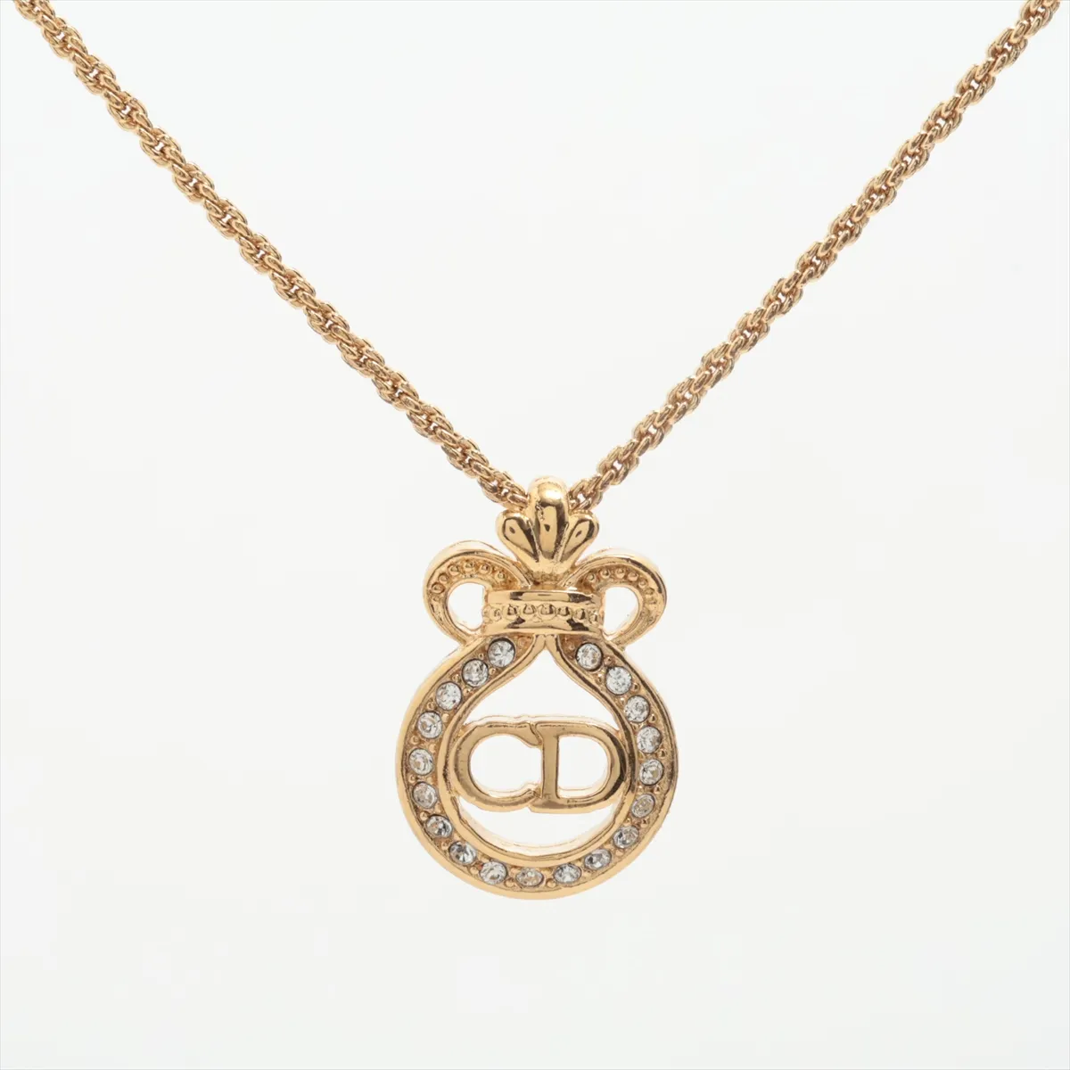 CD logo necklace, gold plated with rhinestones. Shows signs of wear, tarnishing,