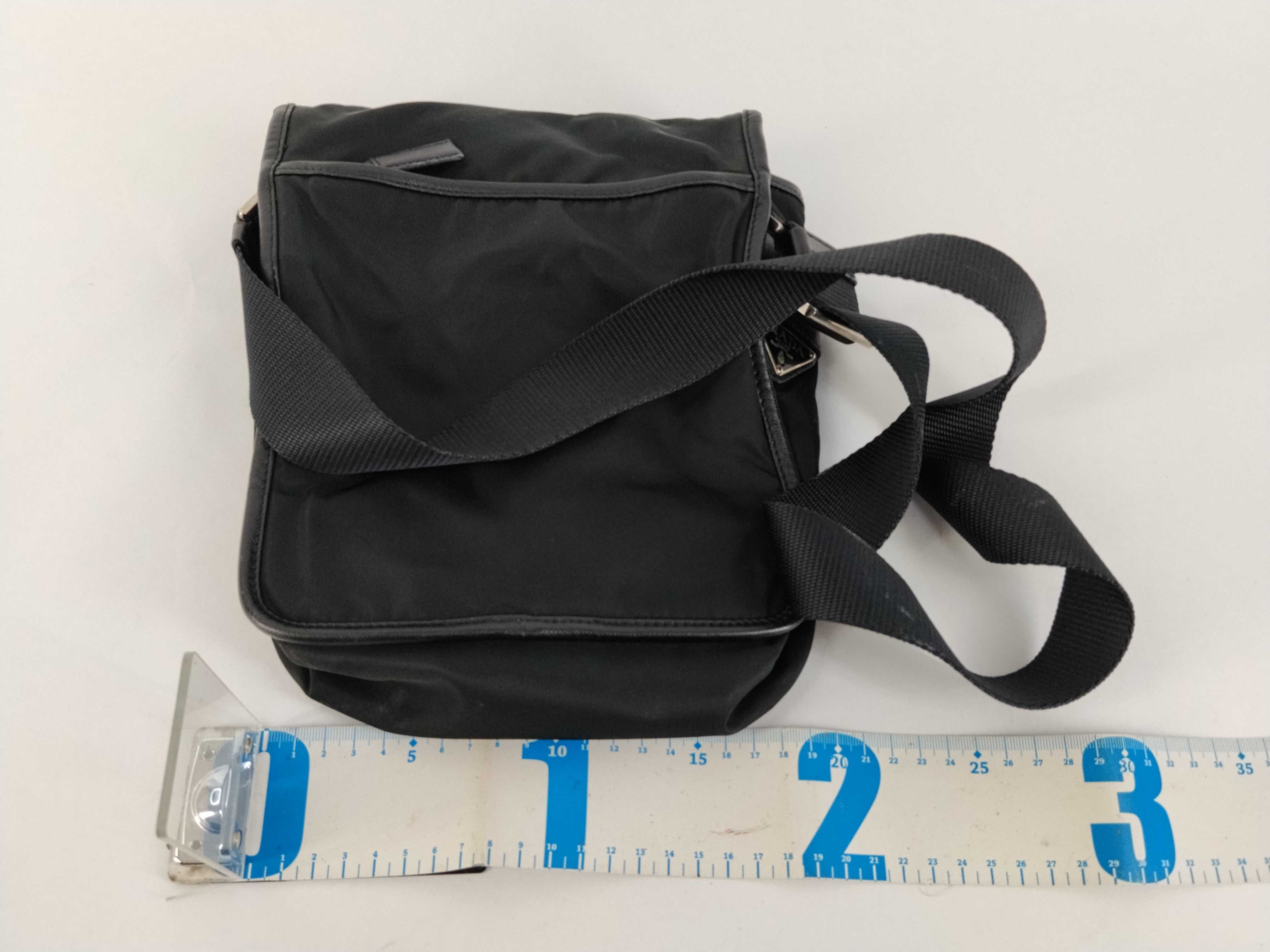 nylon shoulder bag with triangular logo plate, black nylon, white tag, and dust bag. — view 2