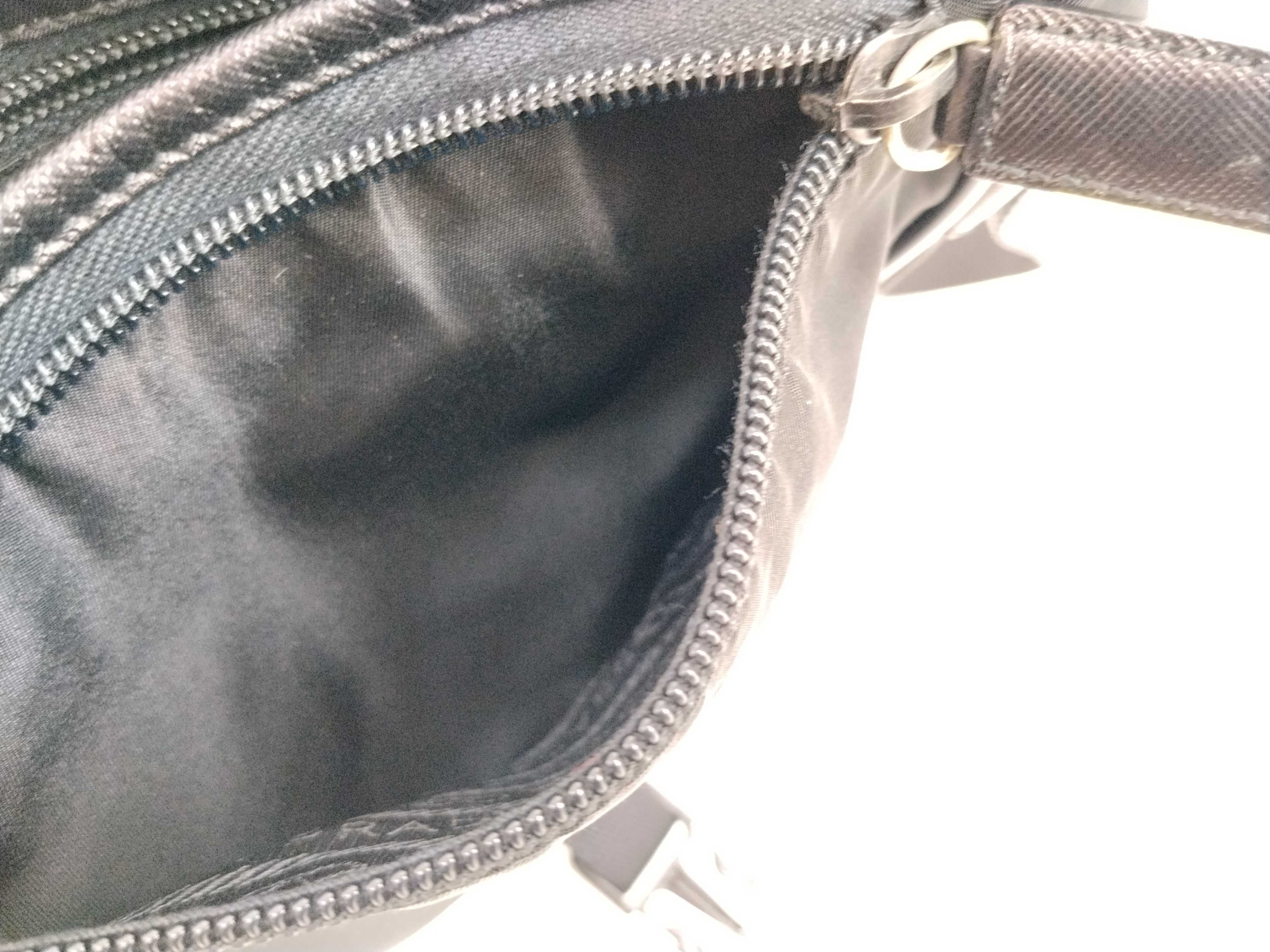 nylon shoulder bag with triangular logo plate, black nylon, white tag, and dust bag. — view 15