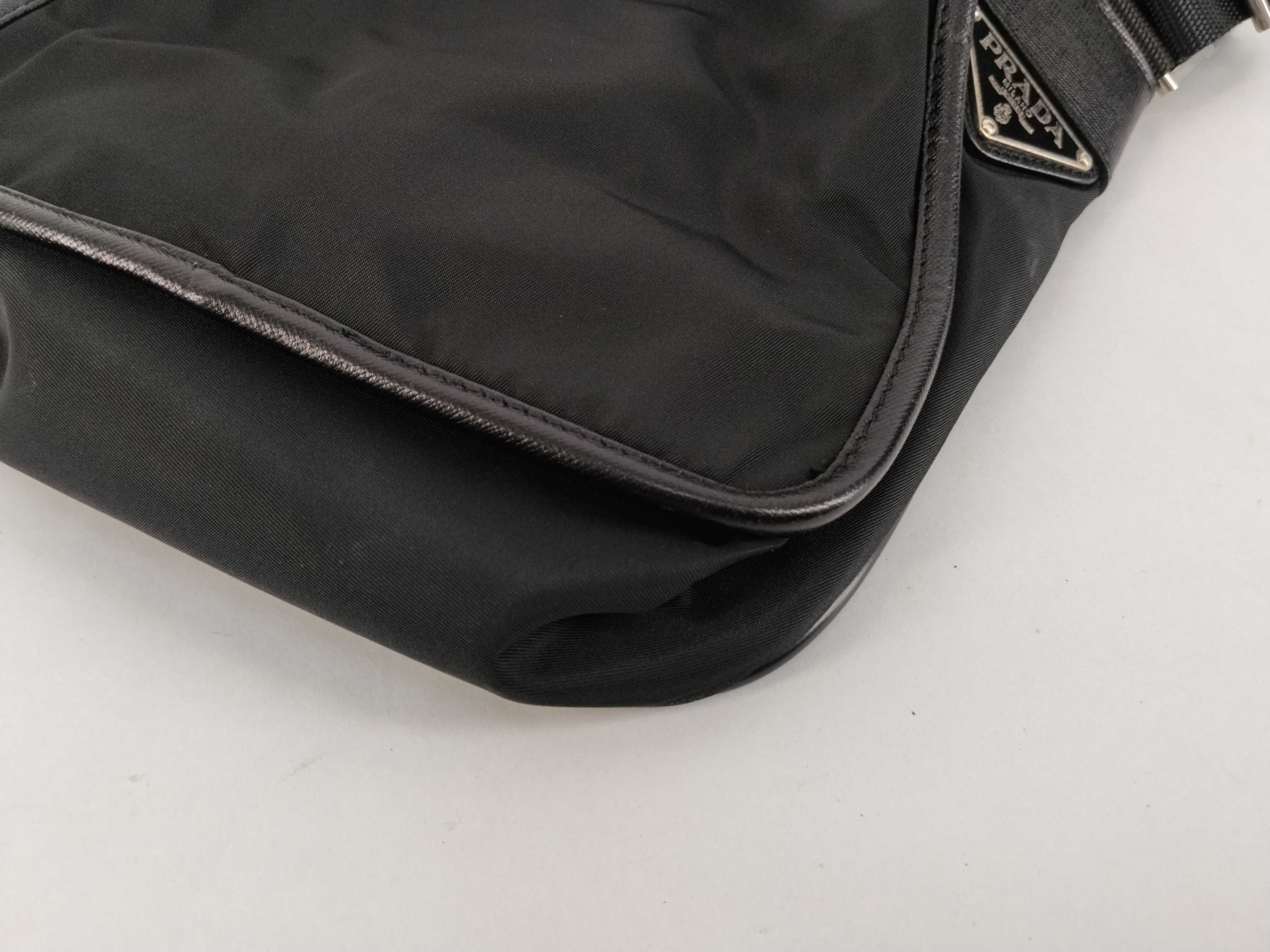 nylon shoulder bag with triangular logo plate, black nylon, white tag, and dust bag. — view 6