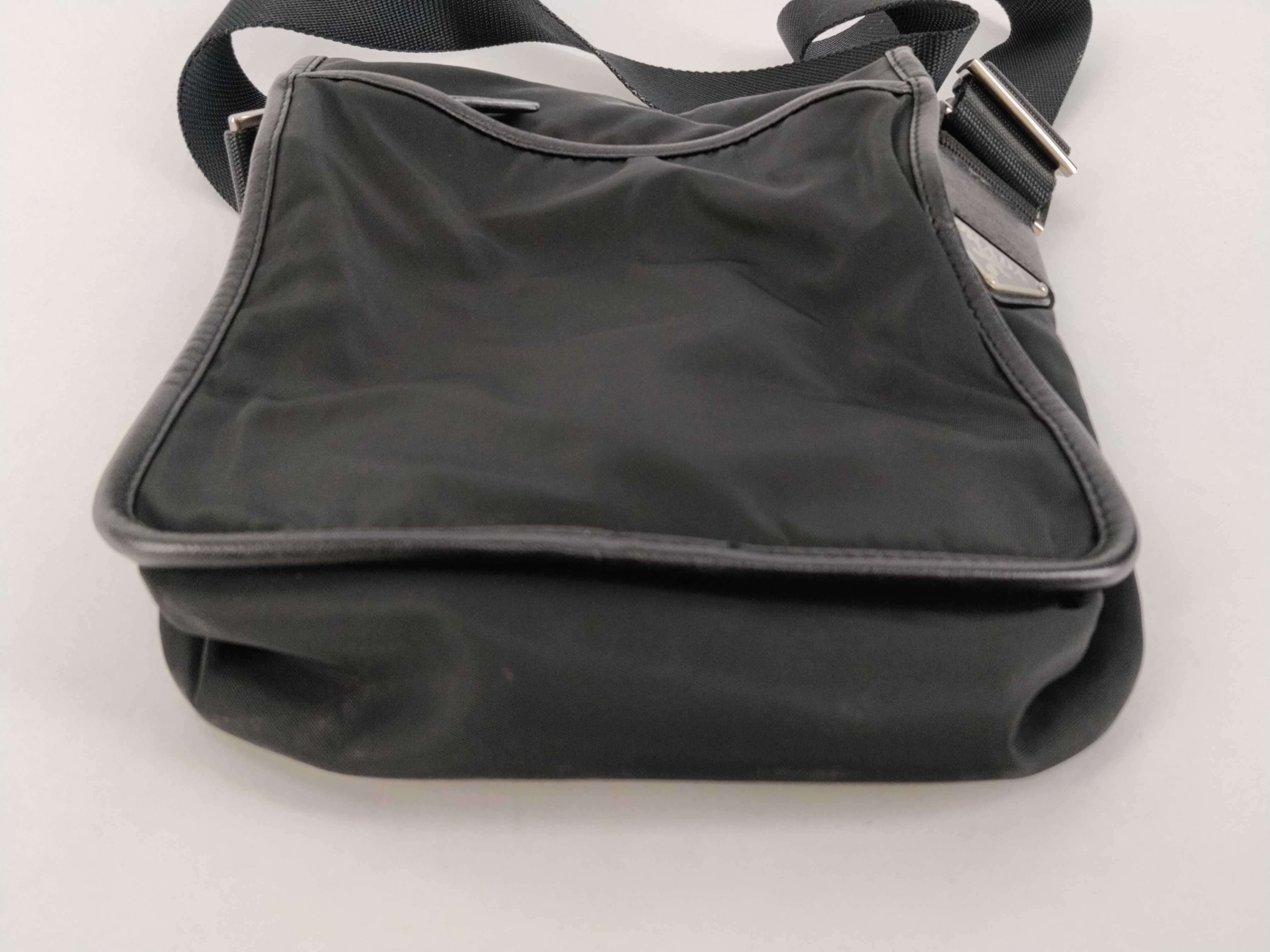 nylon shoulder bag with triangular logo plate, black nylon, white tag, and dust bag. — view 7