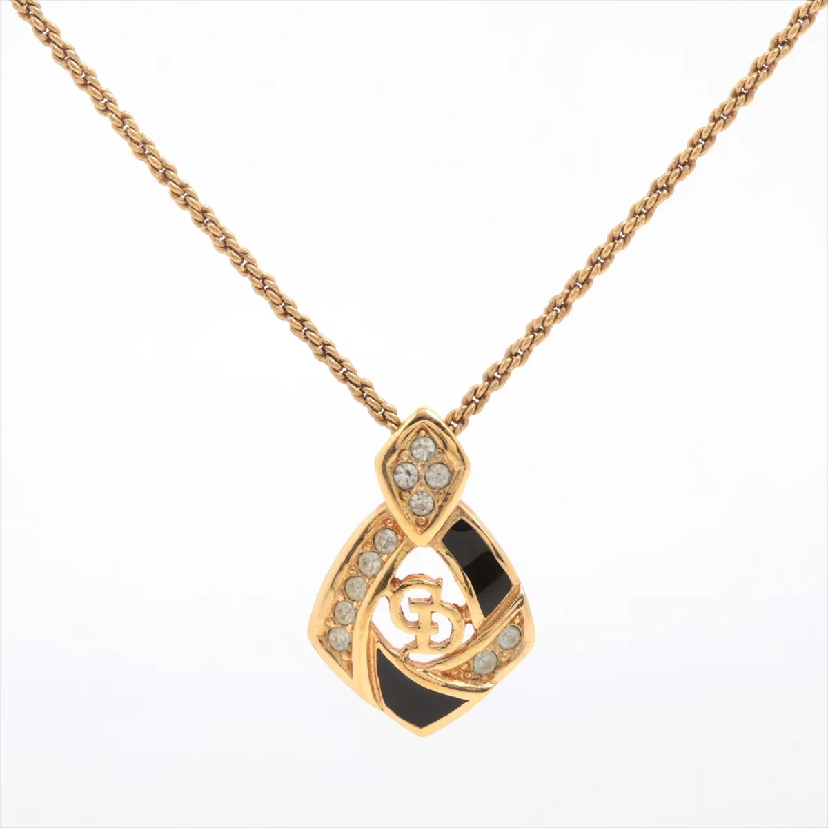 CD logo necklace, gold plated with rhinestones. Shows signs of wear, tarnishing,