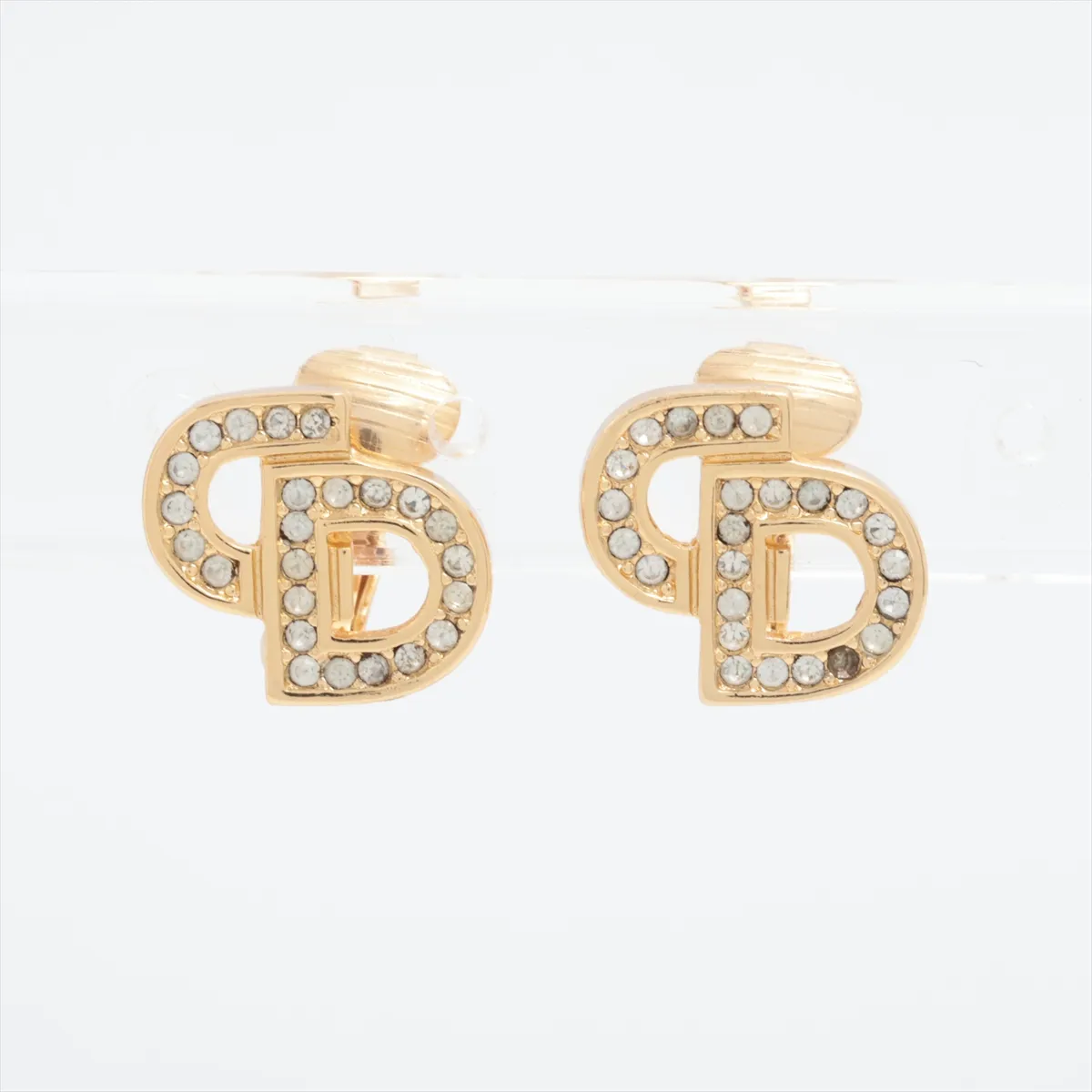 CD logo earrings (for both ears), gold-plated with rhinestones. Shows wear, tarnishing,