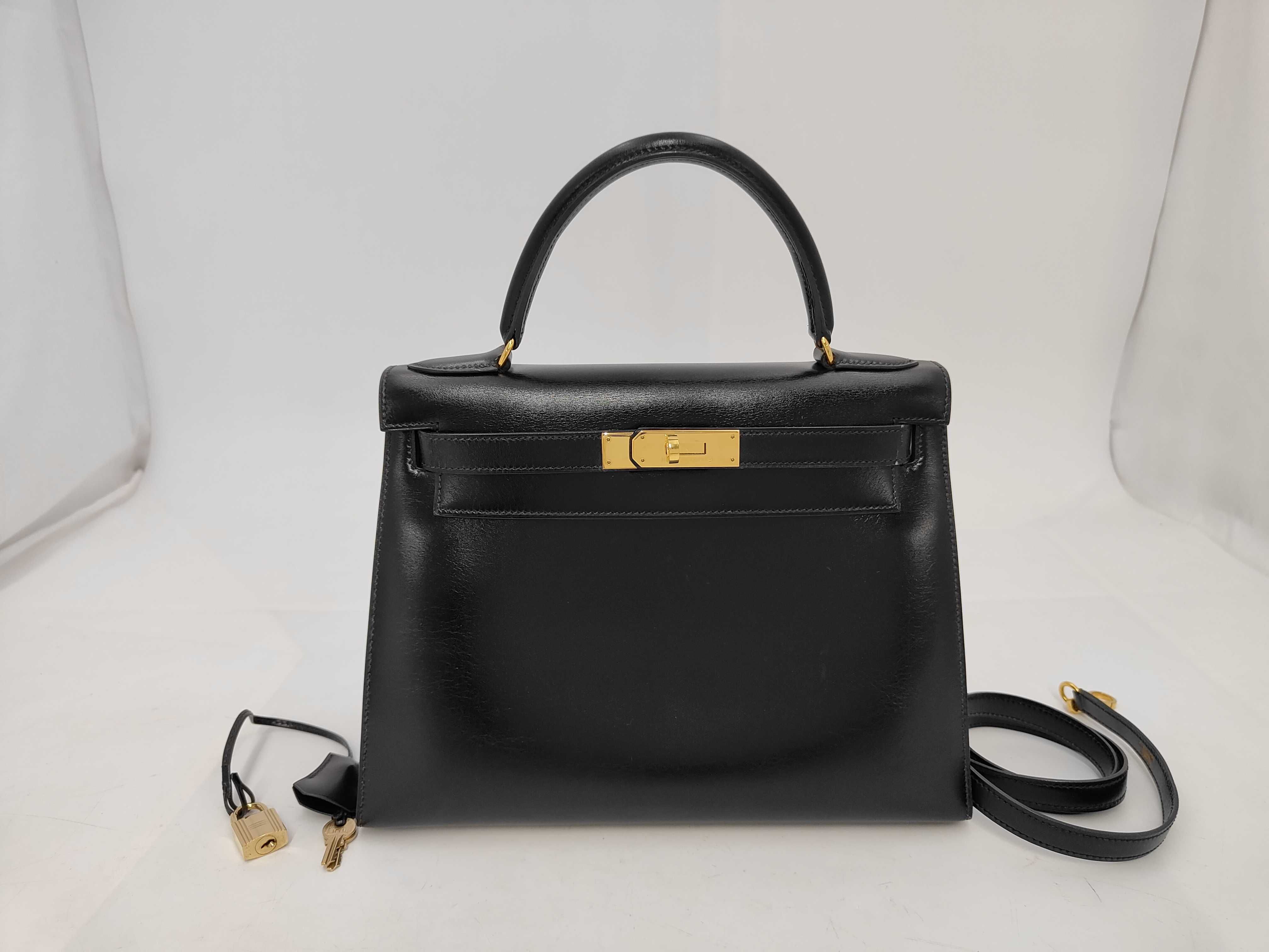 Kelly 28, 2-way, Box Calf leather, black, with V-stamp, includes strap, clochette, key, and 2 keys. 28 x 20 x 11 cm.