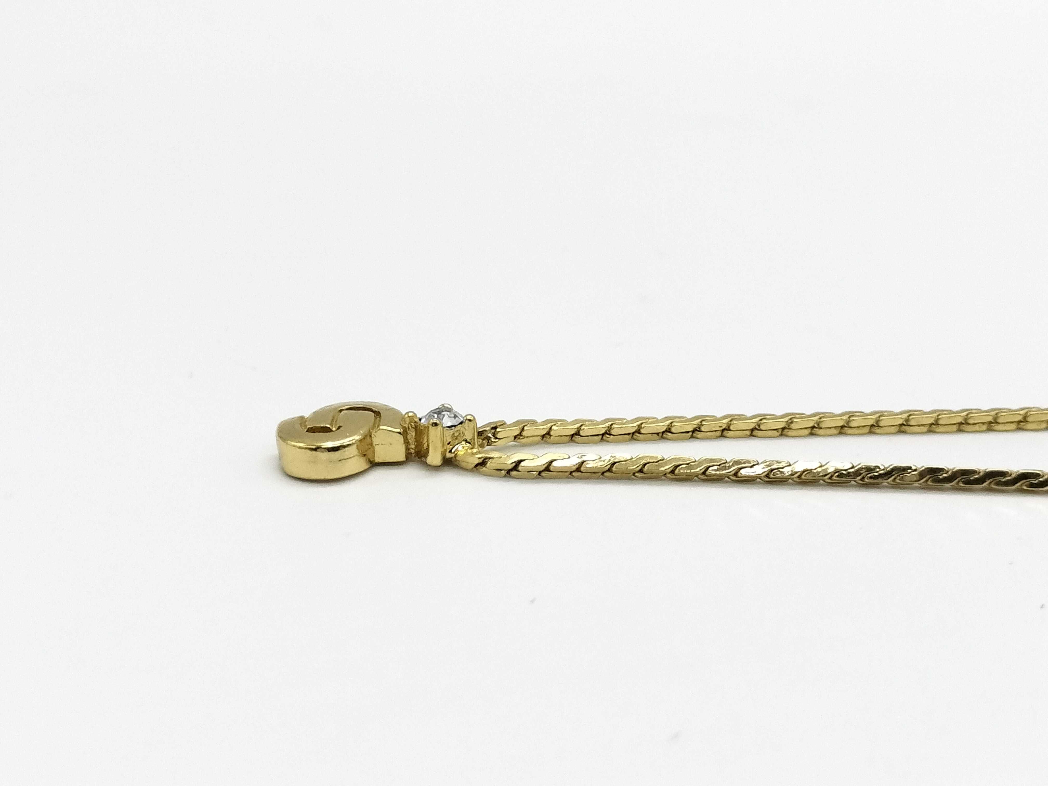 gold-colored necklace with CD logo and gemstone. — view 2