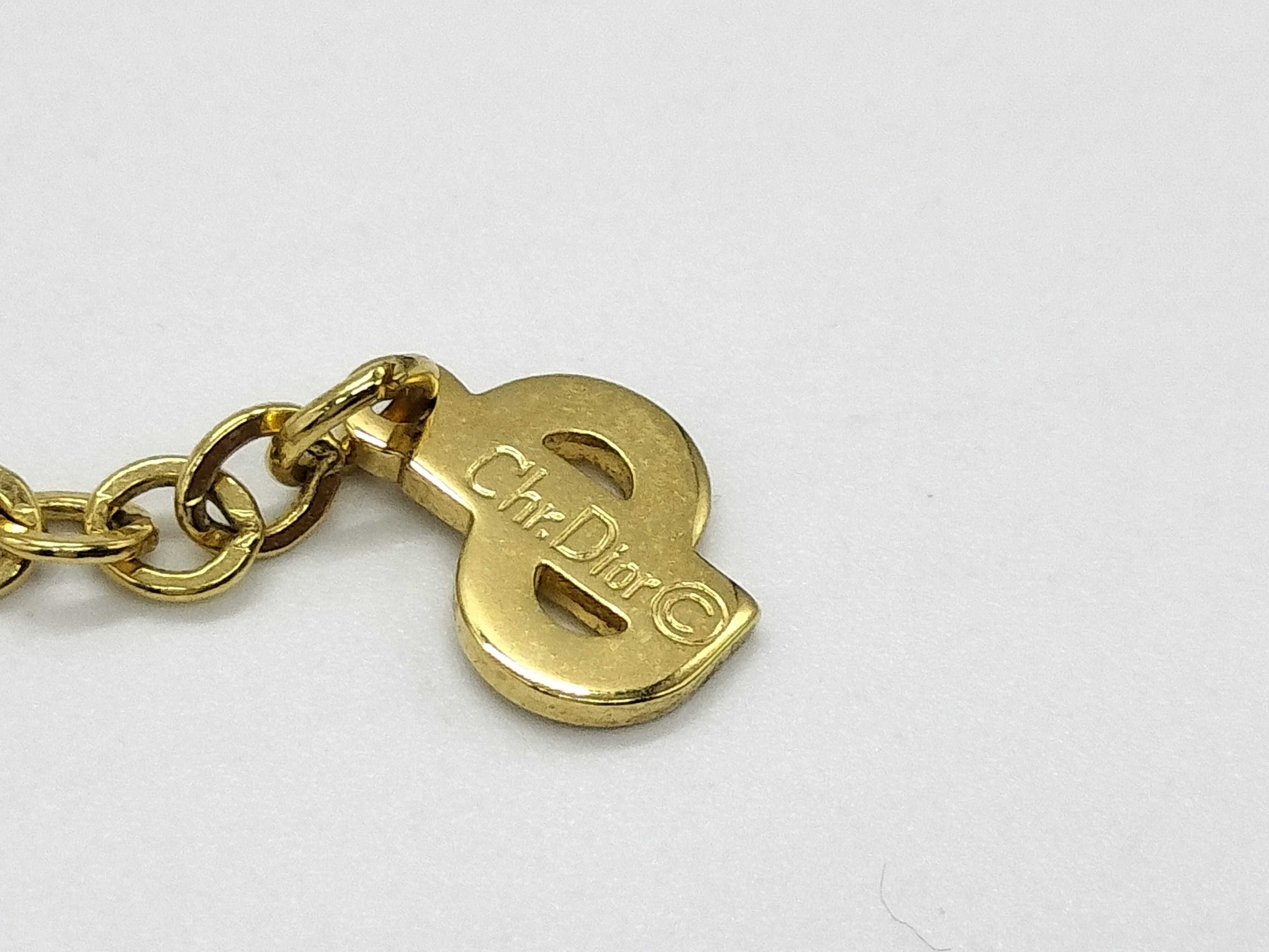 gold-colored necklace with CD logo and gemstone. — view 4