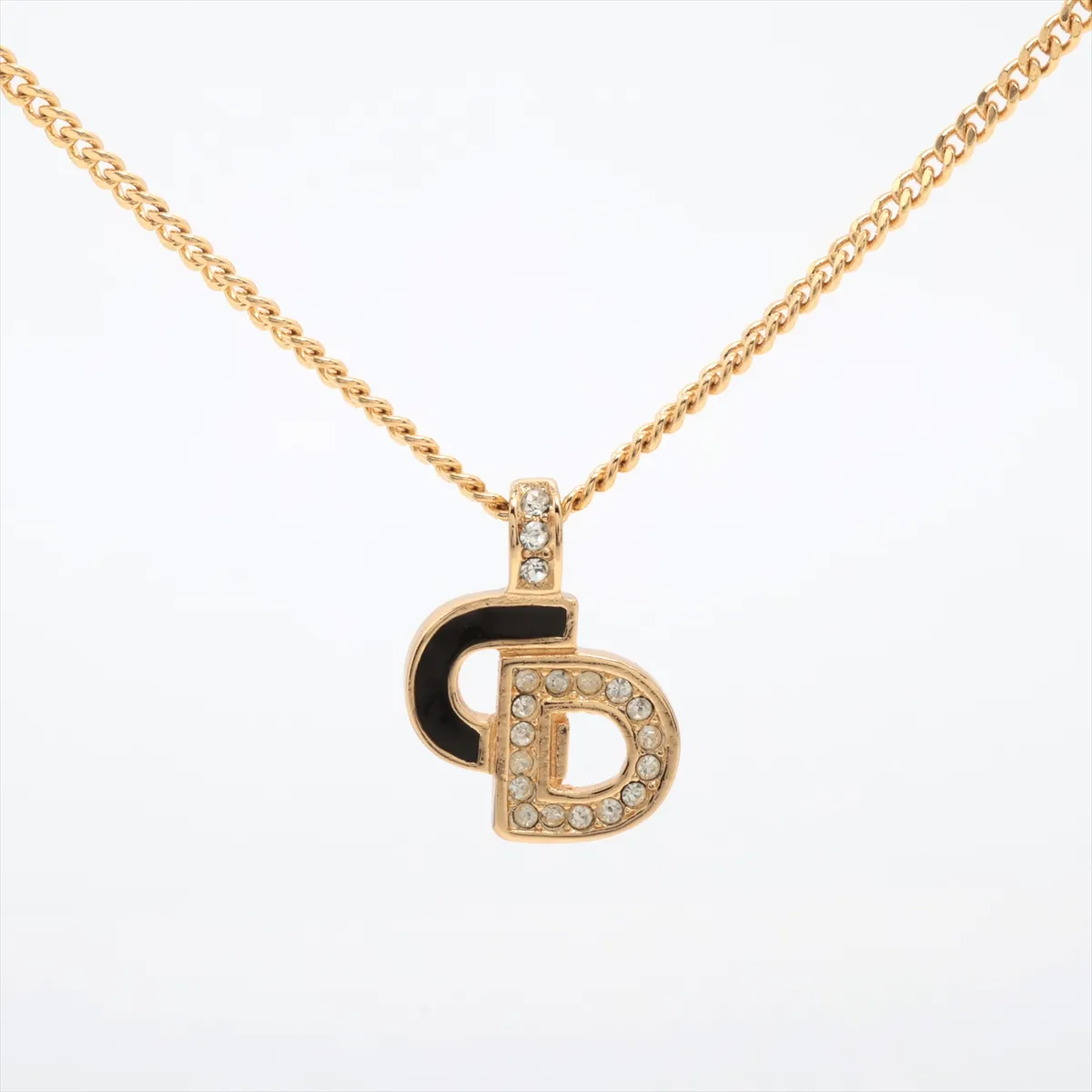 CD logo necklace, gold plated with rhinestones. Shows signs of wear, including