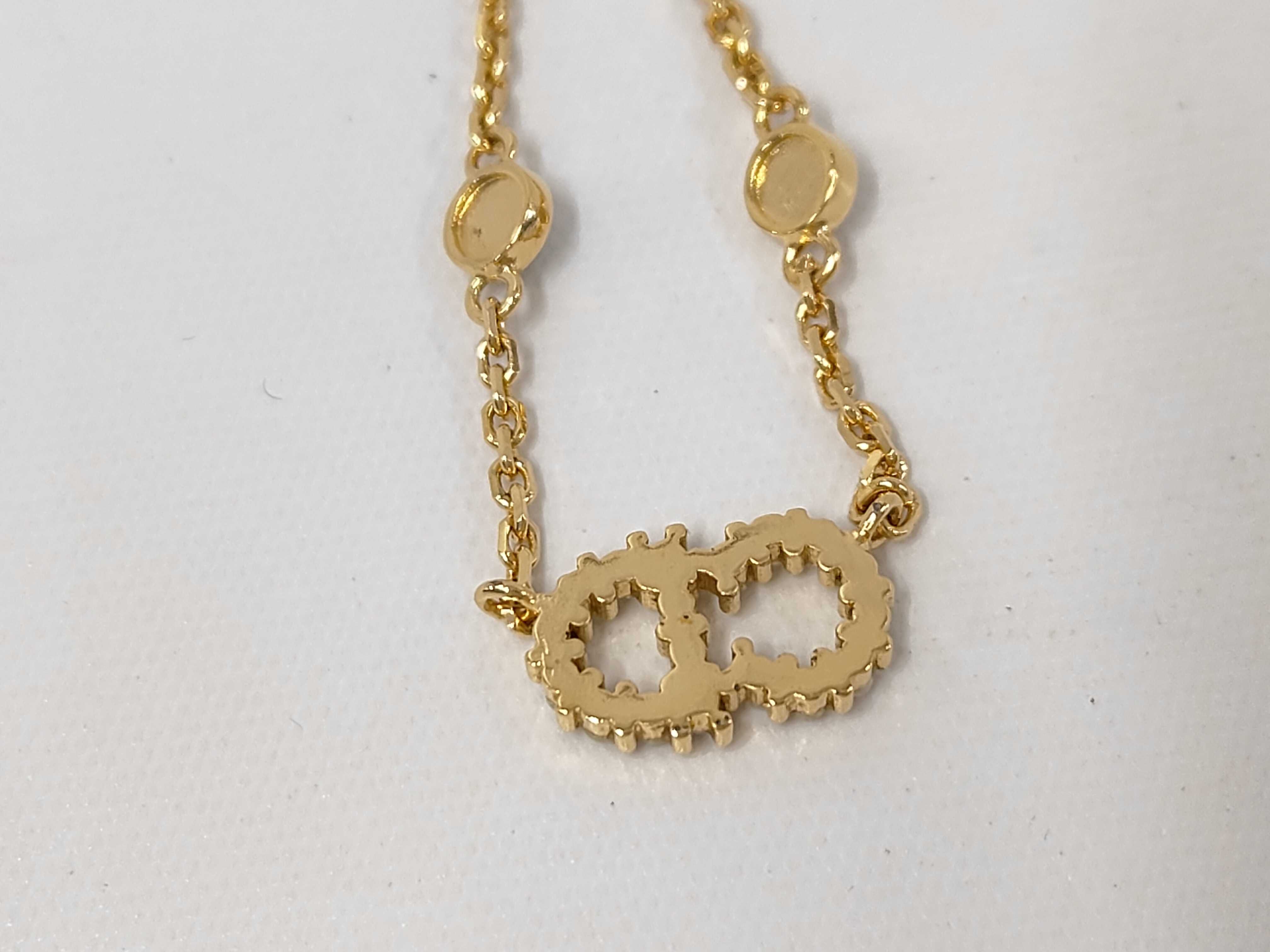 necklace with logo, pearl, and gold accents. — view 2
