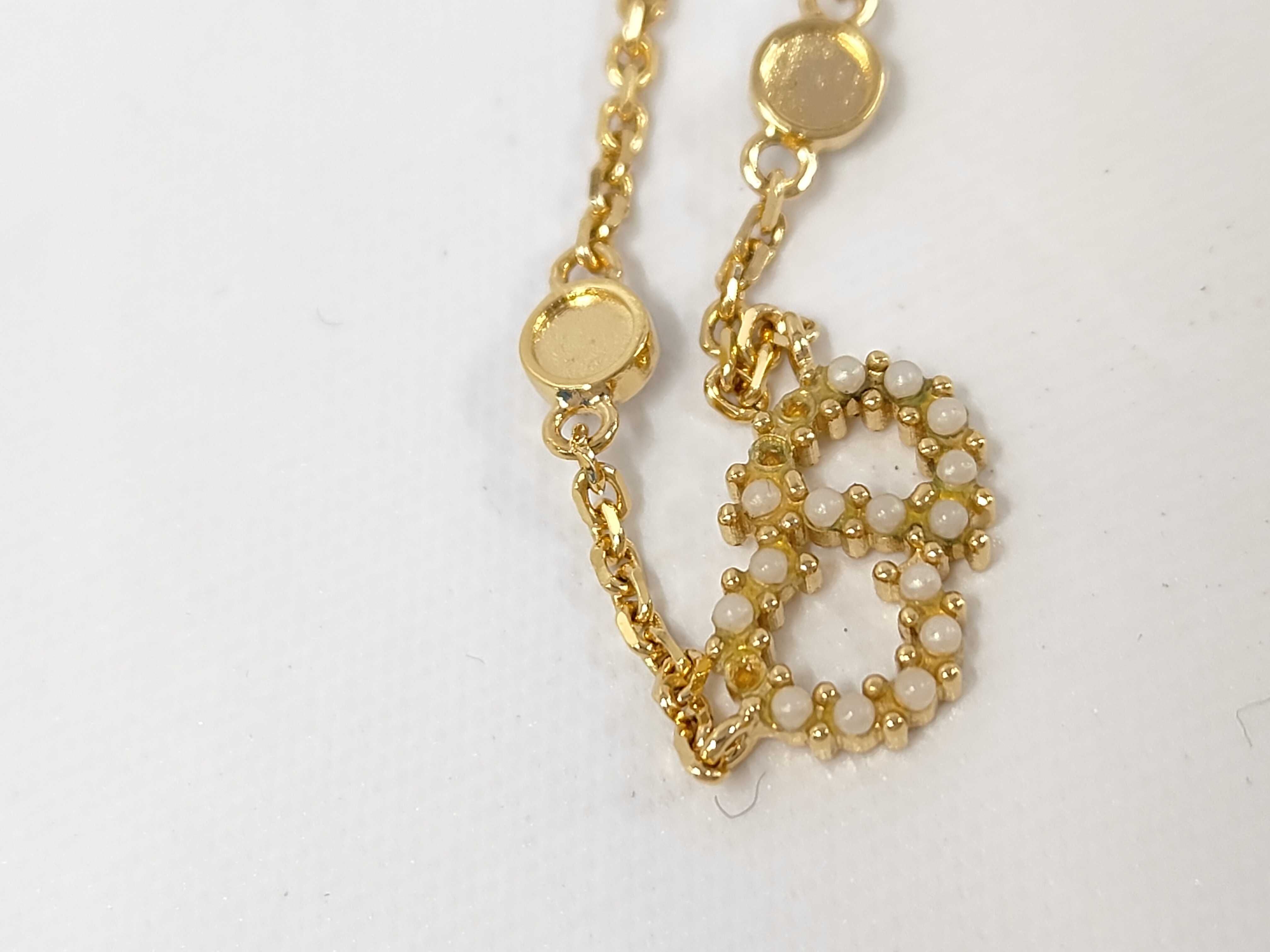 necklace with logo, pearl, and gold accents. — view 9