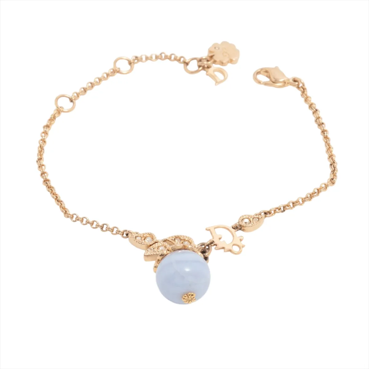 logo bracelet, gold-plated with rhinestones and colored stones, blue and gold. Shows wear, tarnishing, and discoloration.
