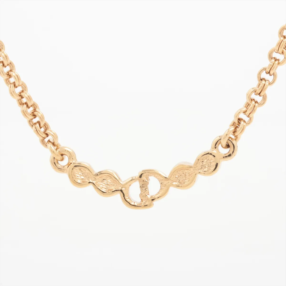 CD logo necklace, gold-plated with rhinestones. Shows wear, tarnishing, and discoloration. — view 2