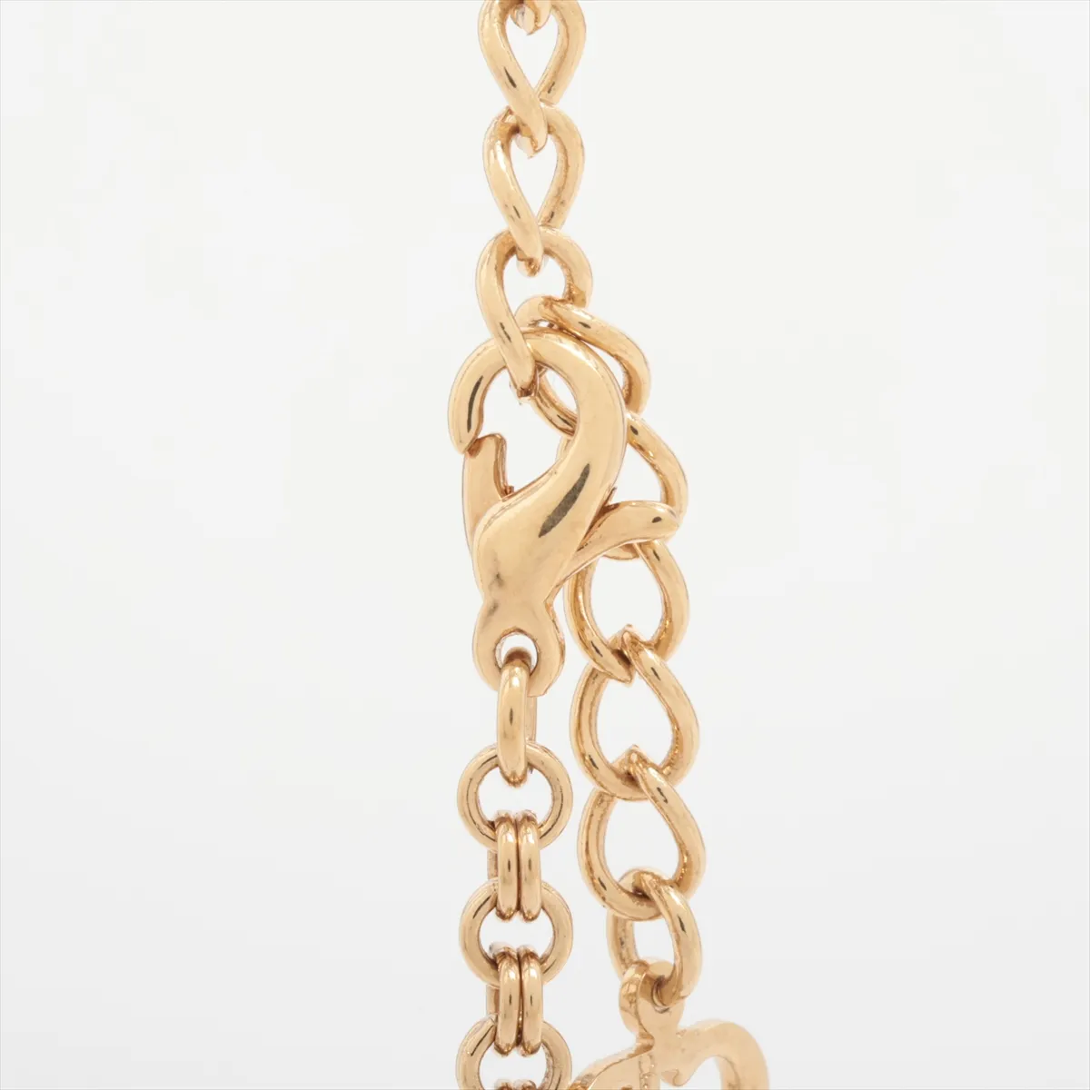 CD logo necklace, gold-plated with rhinestones. Shows wear, tarnishing, and discoloration. — view 3