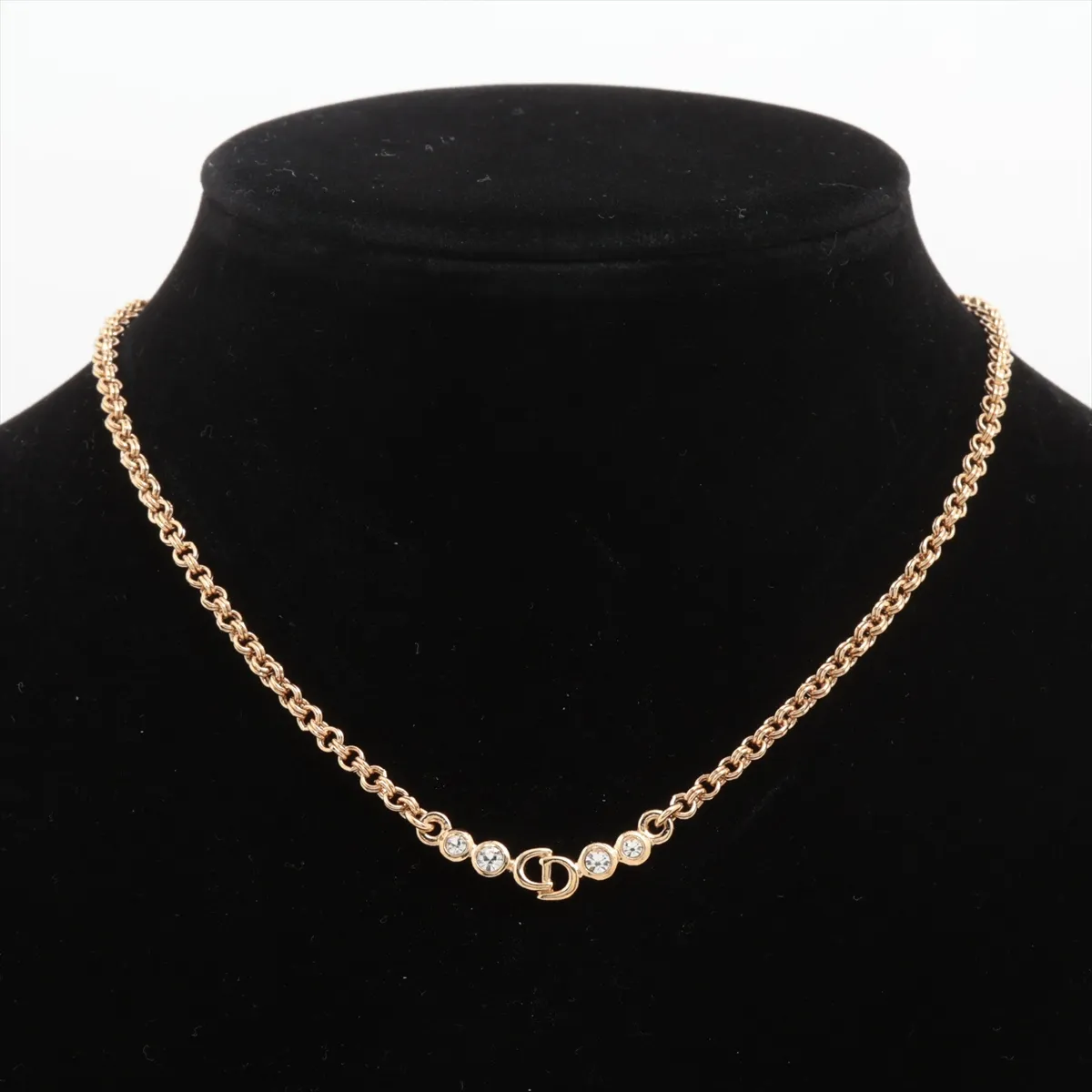 CD logo necklace, gold-plated with rhinestones. Shows wear, tarnishing, and discoloration. — view 5