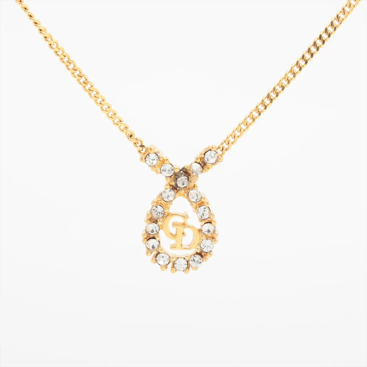 CD logo necklace, gold plated with rhinestones. Shows signs of wear, including