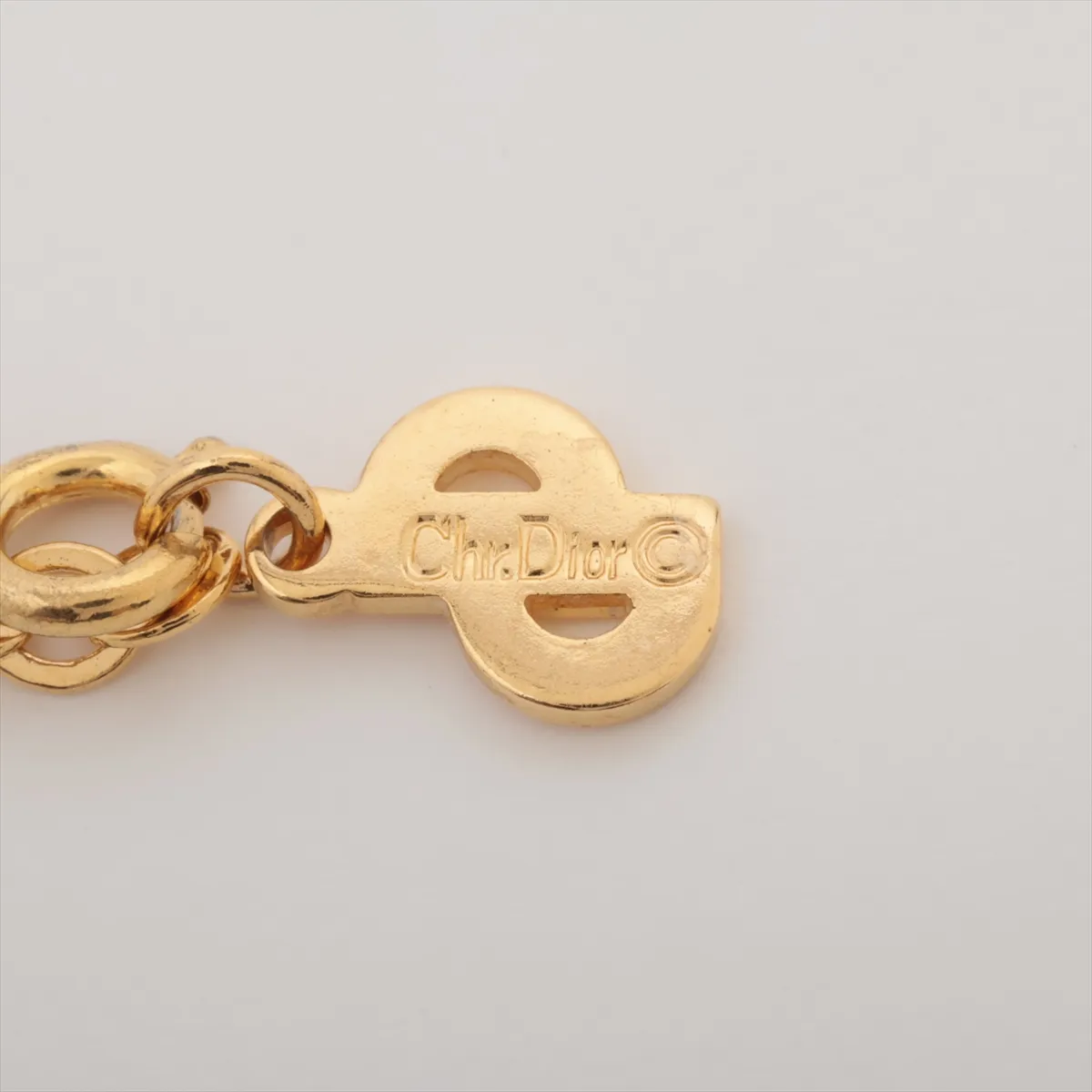 CD logo necklace, gold plated with rhinestones, shows signs of wear, tarnishing, — view 4