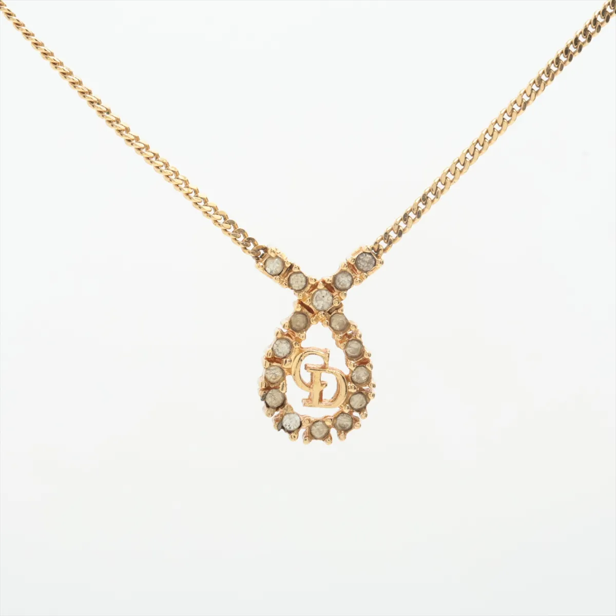 CD logo necklace, gold plated with rhinestones. Shows signs of wear, including