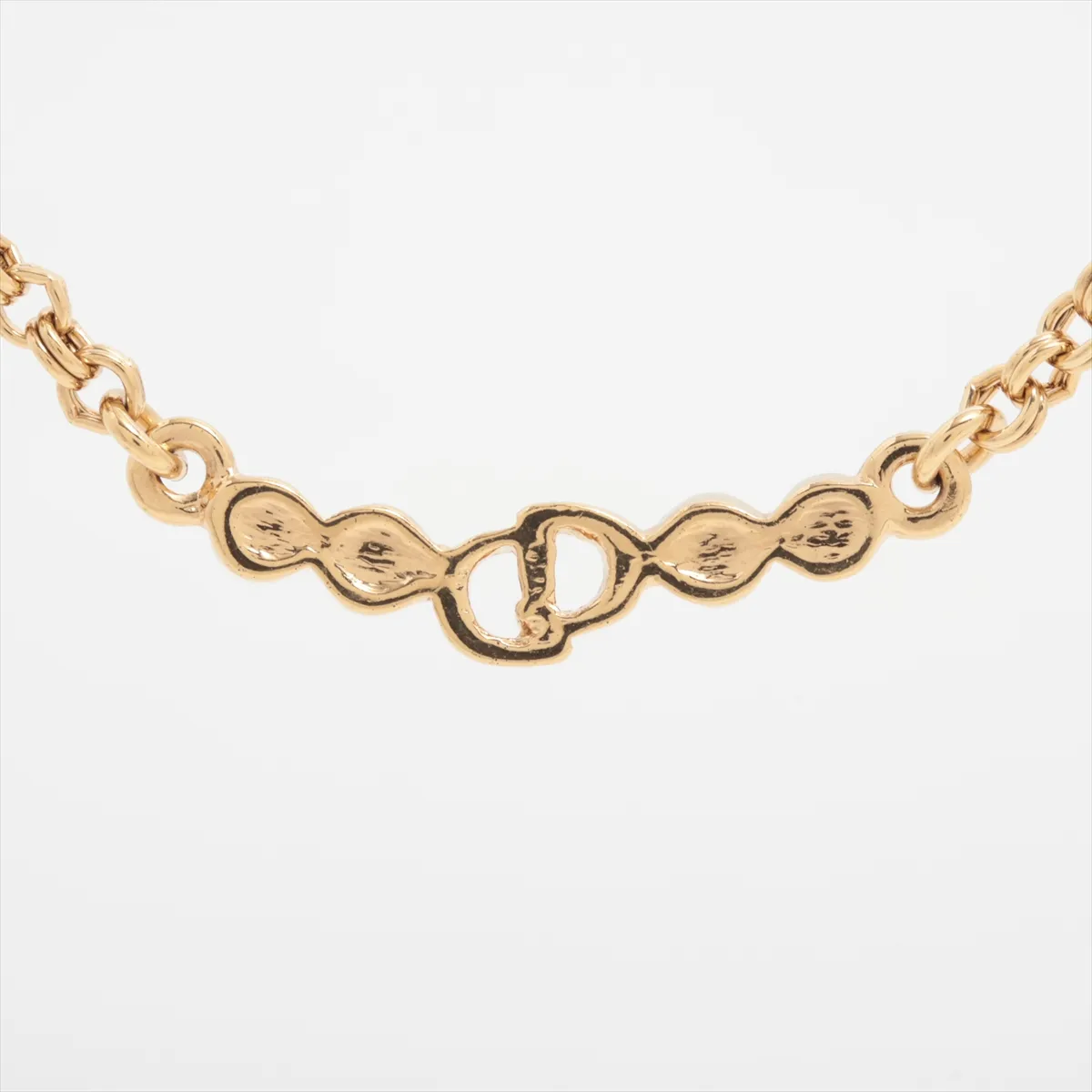 CD logo necklace, gold plated with rhinestones. Shows signs of wear, including — view 2