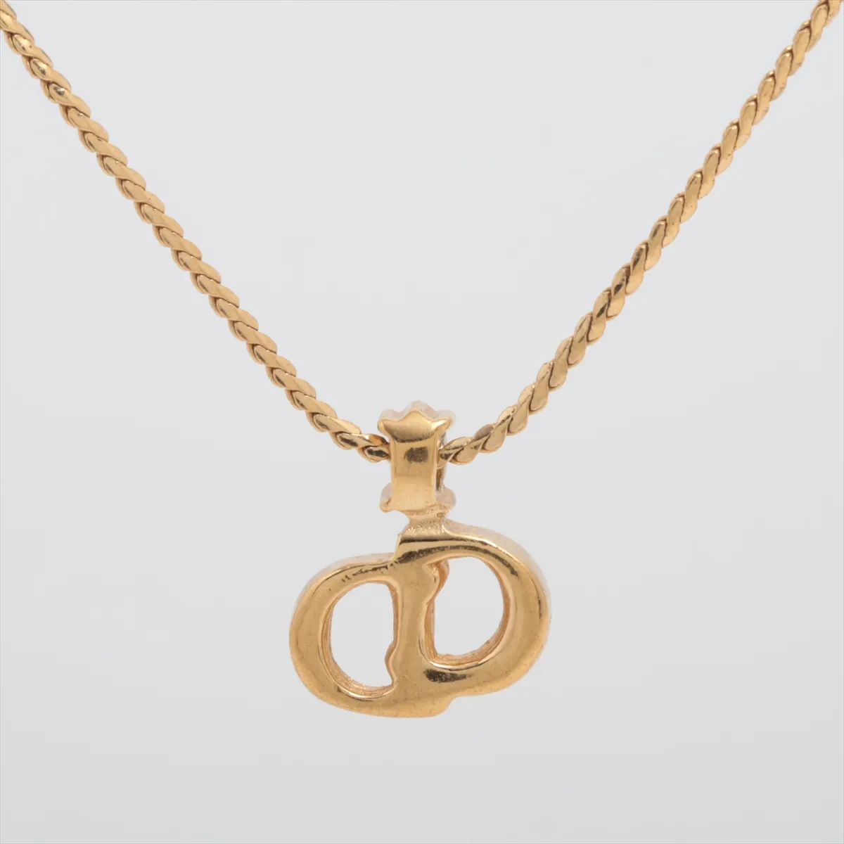 CD logo necklace, gold plated with rhinestones. Shows signs of wear, including — view 2