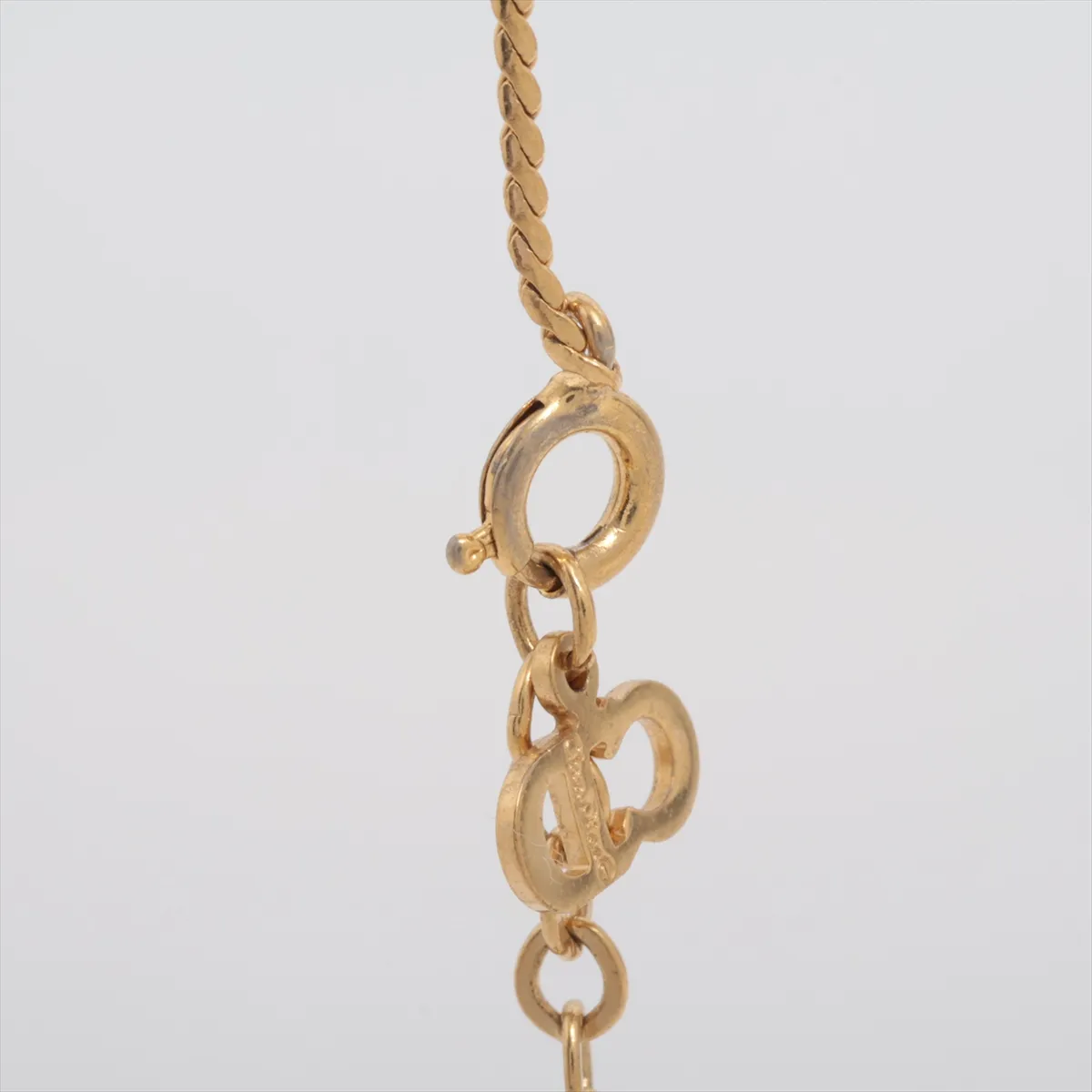 CD logo necklace, gold plated with rhinestones. Shows signs of wear, including — view 3