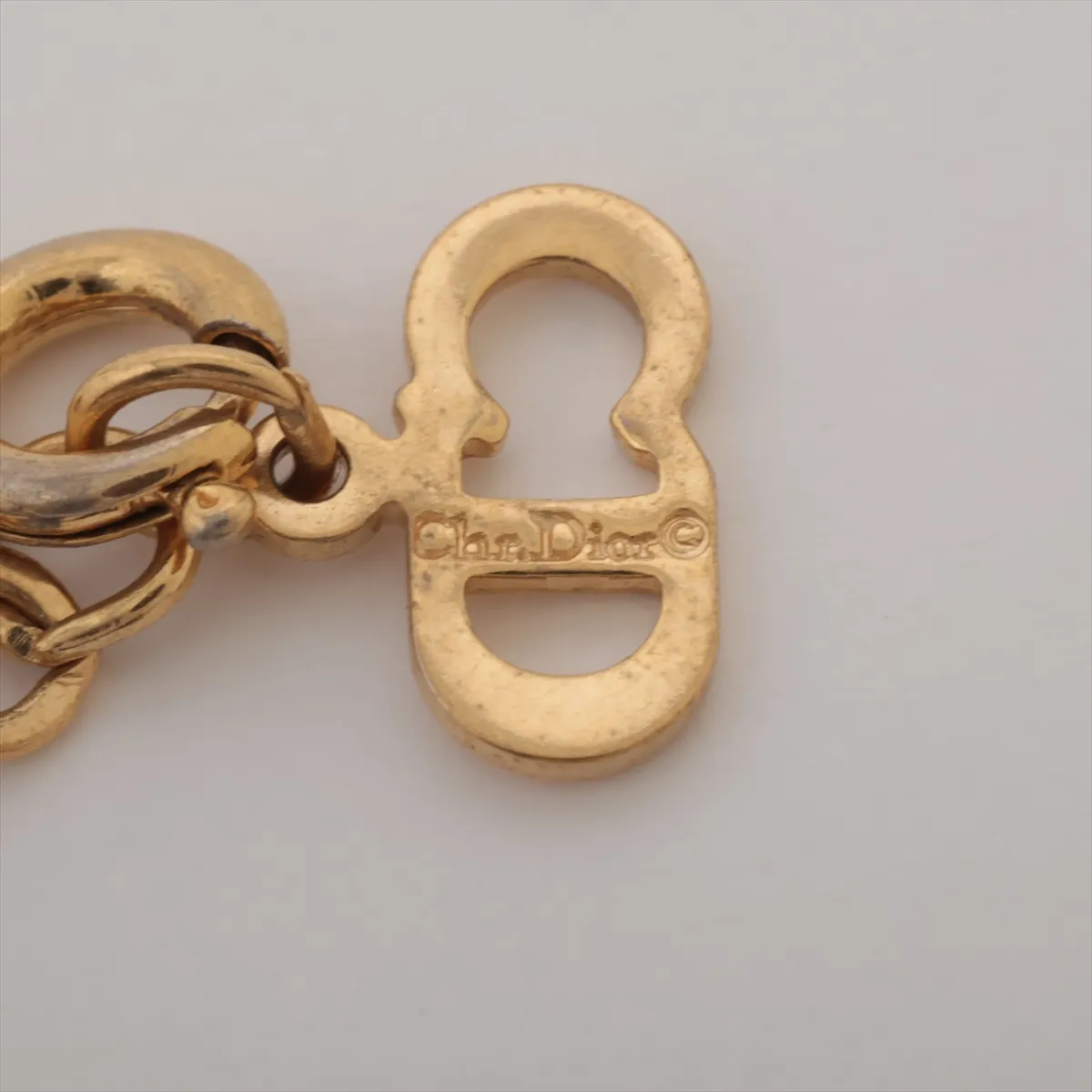 CD logo necklace, gold plated with rhinestones. Shows signs of wear, including — view 4