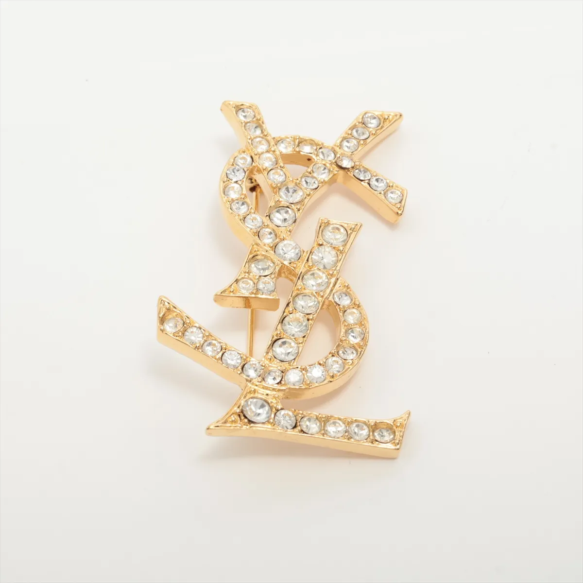 logo brooch, gold plated with rhinestones. Shows signs of wear,