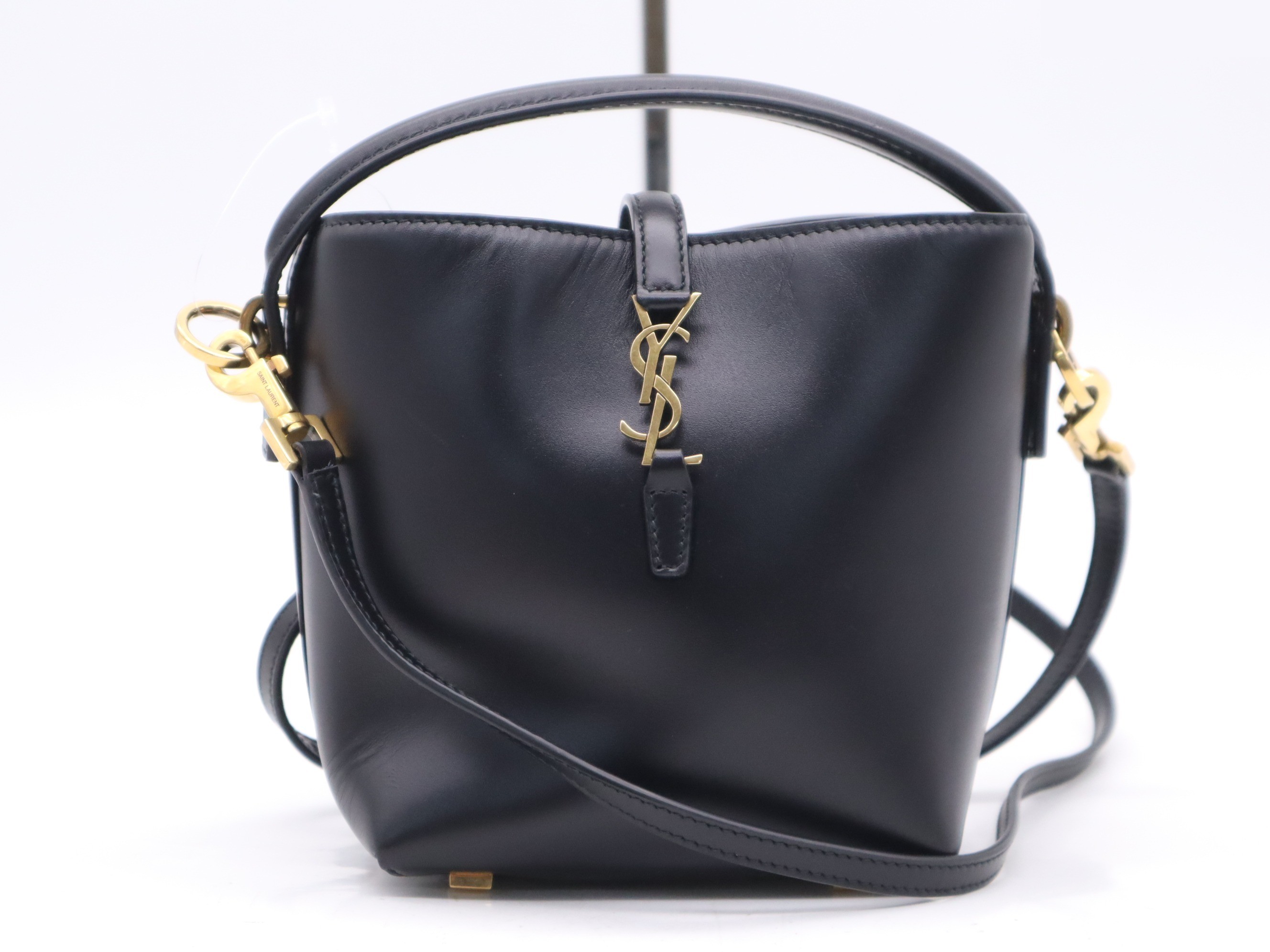 Leather YSL logo bucket bag, black, gold hardware, with shoulder strap.