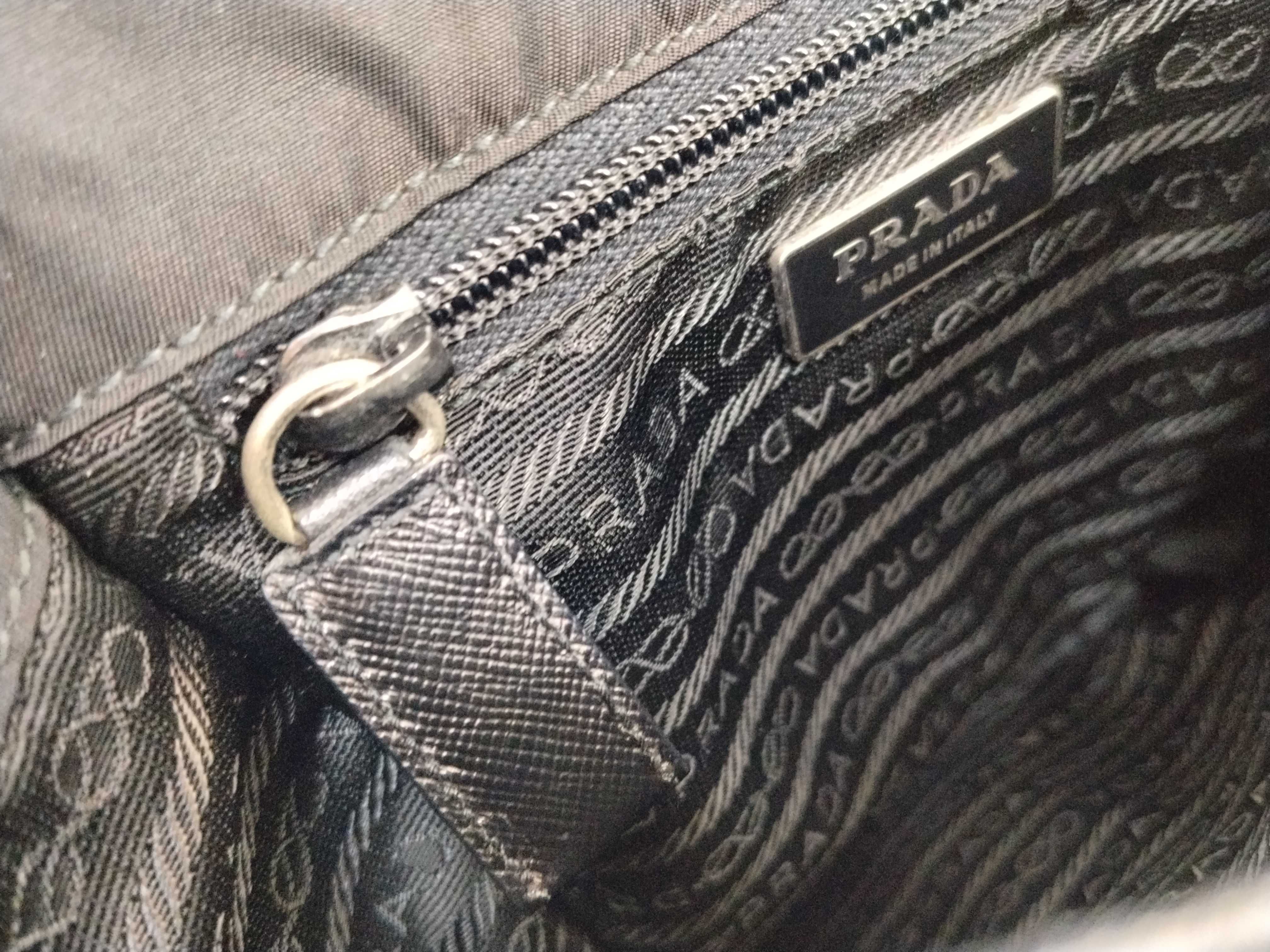nylon shoulder bag with triangular logo plate, black nylon, white tag, and dust bag. — view 13