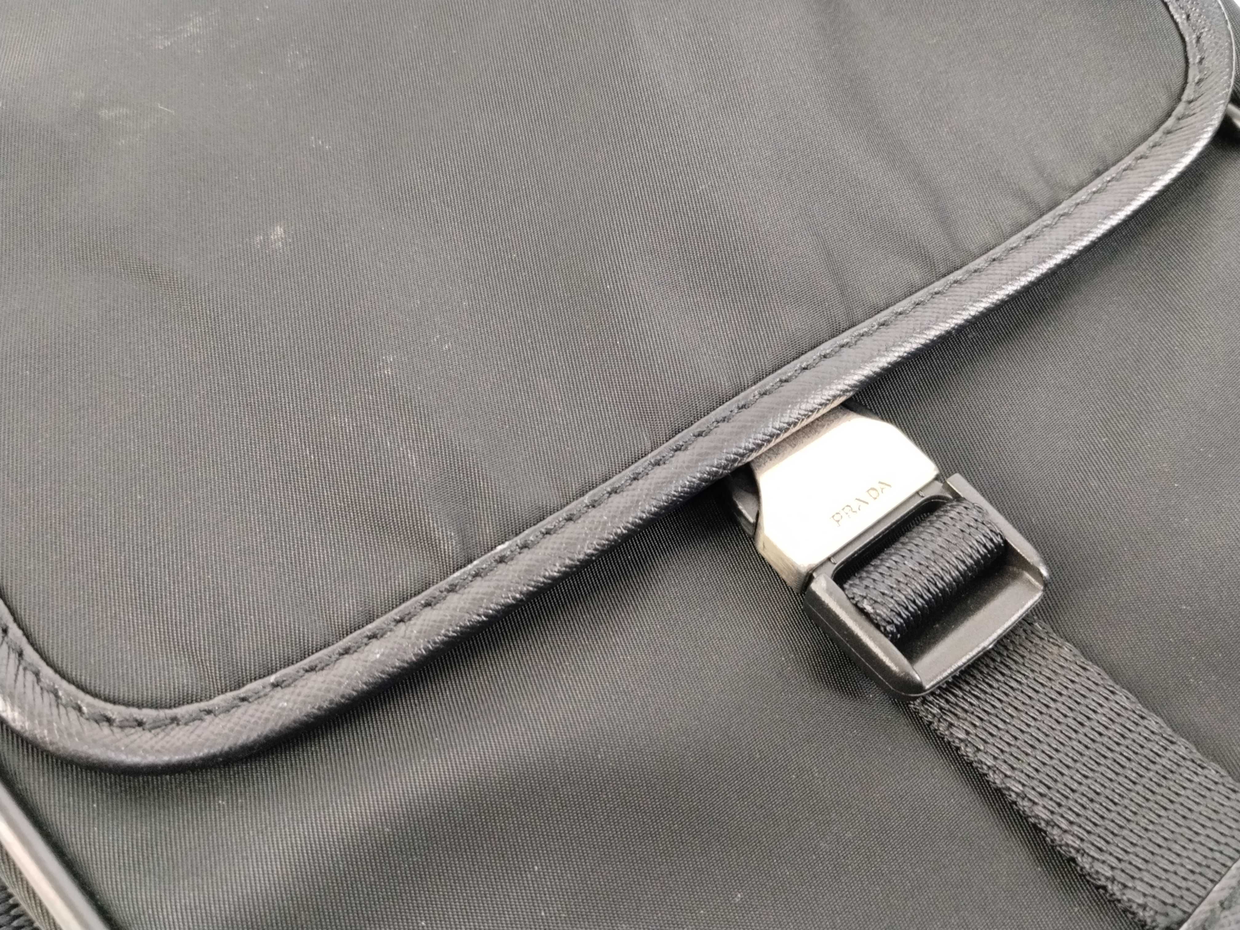 nylon shoulder bag with triangular logo plate, black nylon, white tag, and dust bag. — view 8
