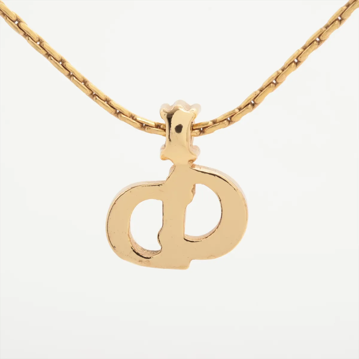 CD logo necklace, gold plated with rhinestones. Shows signs of wear, including — view 2