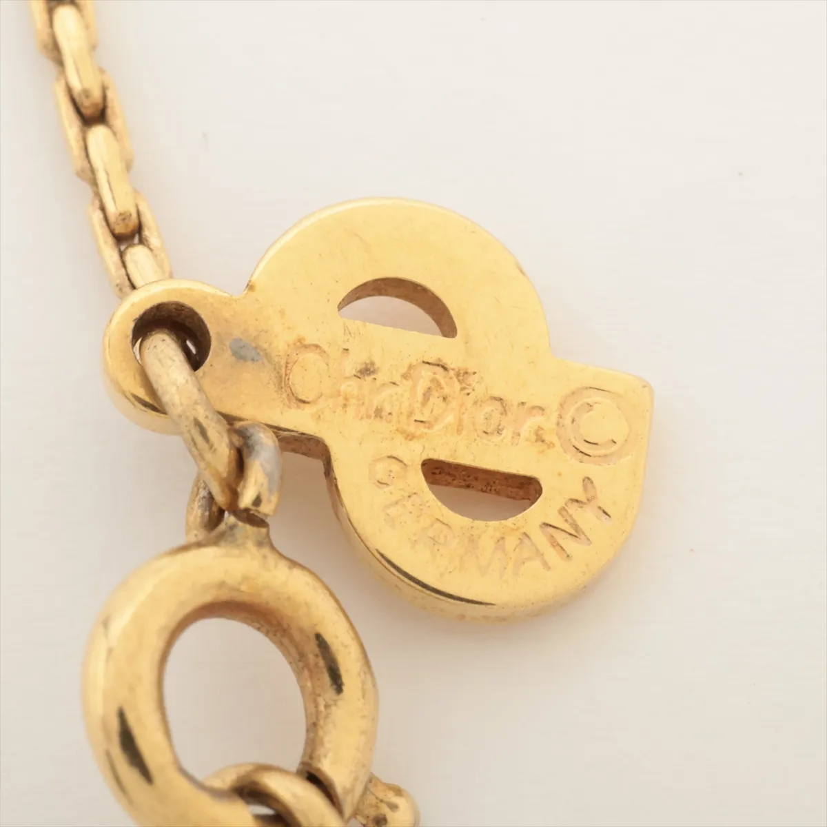 CD logo necklace, gold plated with rhinestones. Shows signs of wear, including — view 4