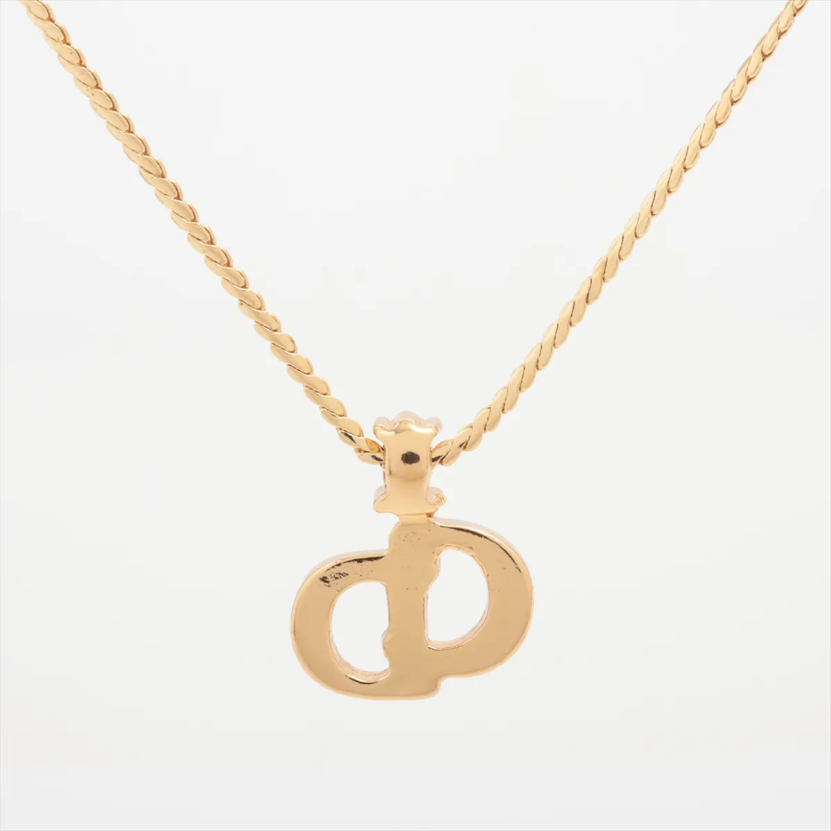 CD logo necklace, gold-plated with rhinestones. Shows wear, tarnishing, and discoloration. — view 2