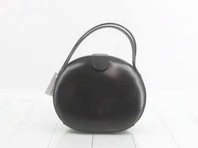 Leather handbag, black, round shape.