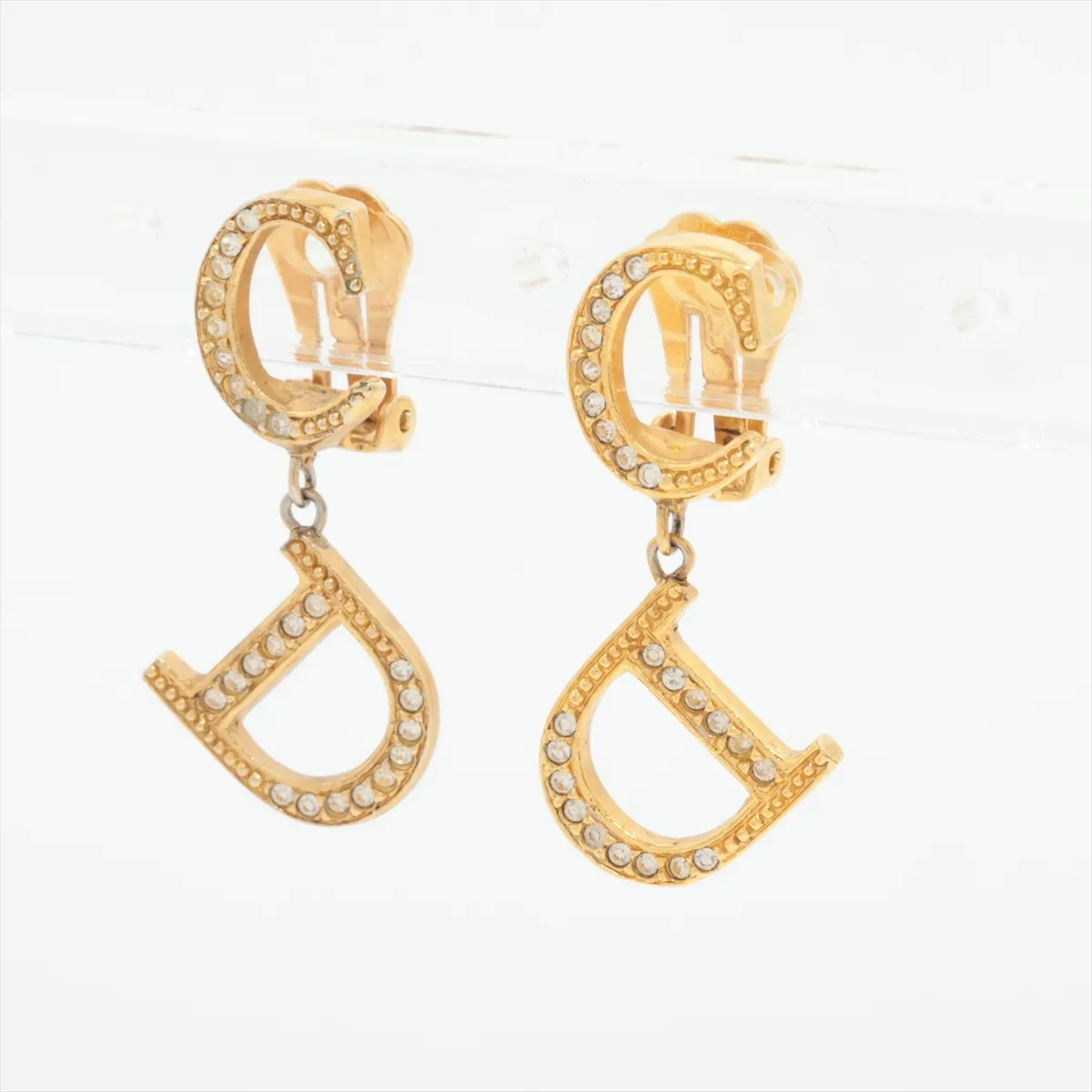 CD logo earrings (for both ears), gold-plated with rhinestones. Shows signs of wear including dents, — view 3