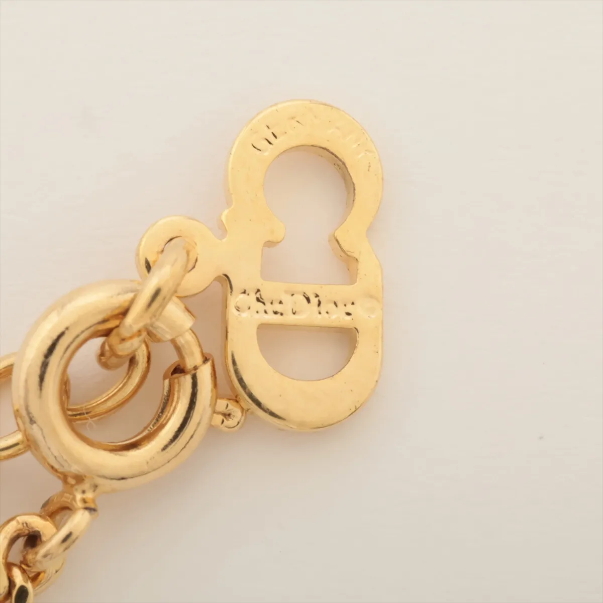 CD logo necklace, gold plated with rhinestones. Shows signs of wear, including — view 4
