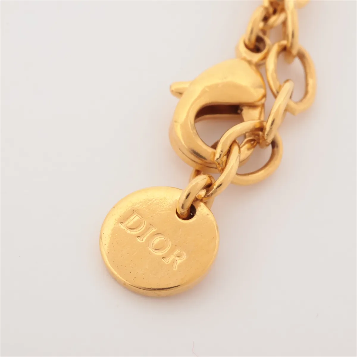 CD logo necklace, gold plated with rhinestones. Shows signs of wear, including — view 4