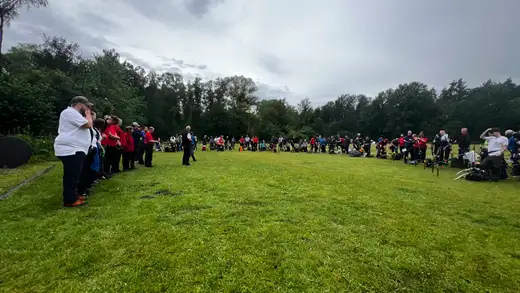 Eine Gruppe von Bogenschützen steht auf einer Wiese vor einem Wald, bereit für die Landesmeisterschaft Feldbogen in Wolfsburg.