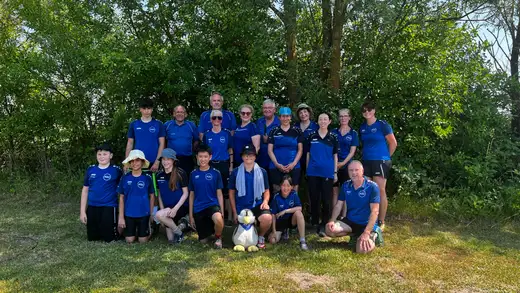 Gruppe von Bogensportlern in blauen Trikots des ASC Göttingen vor einer Baumkulisse bei der Landesmeisterschaft WA im Freien.