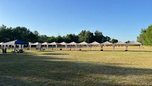 Aufgestellte Pavillons und Zielscheiben auf einer Wiese unter blauem Himmel, bereit für die Landesmeisterschaft WA im Freien.