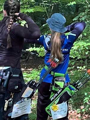 Zwei Schützinnen blicken von der Schießlinie zu einem Ziel im Wald