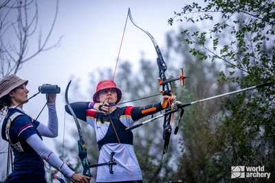Svenja Herrmann steht im Achtelfinale der Feldbogen-WM im Auszug, während Jennifer Devaux durch ihr Fernglas schaut.