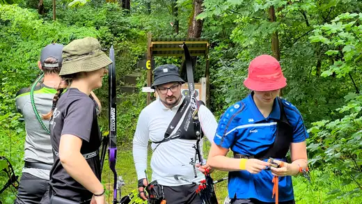 Teilnehmer mit Bögen und Ausrüstung stehen vor einer Zielscheibe im Wald bei der Landesmeisterschaft Feldbogen 2026.