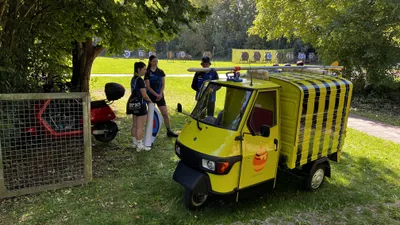 Der geschmückte gelbe Kleintransporter steht neben dem Tor zum Bogenplatz; im Hintergrund sind Zielscheiben zu sehen.