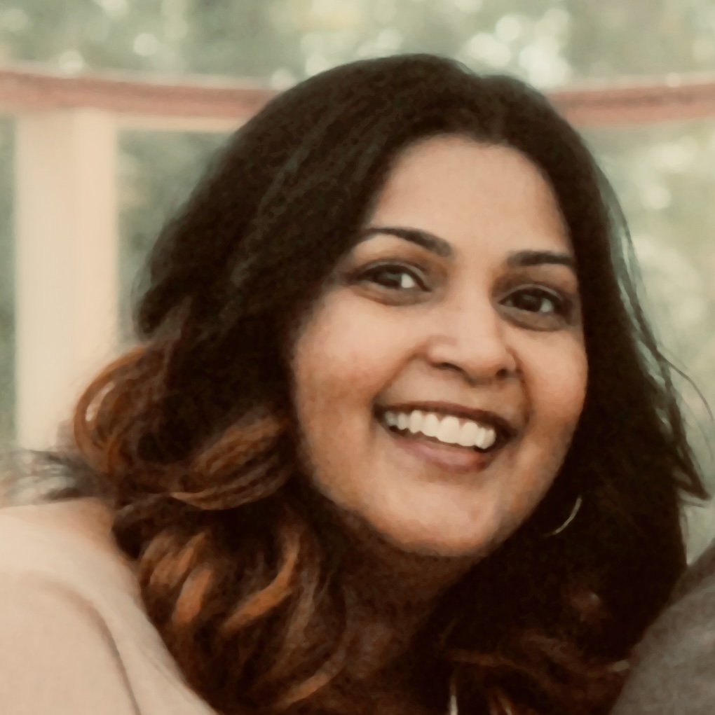 picture of Savitha sitting in an outdoors gazebo