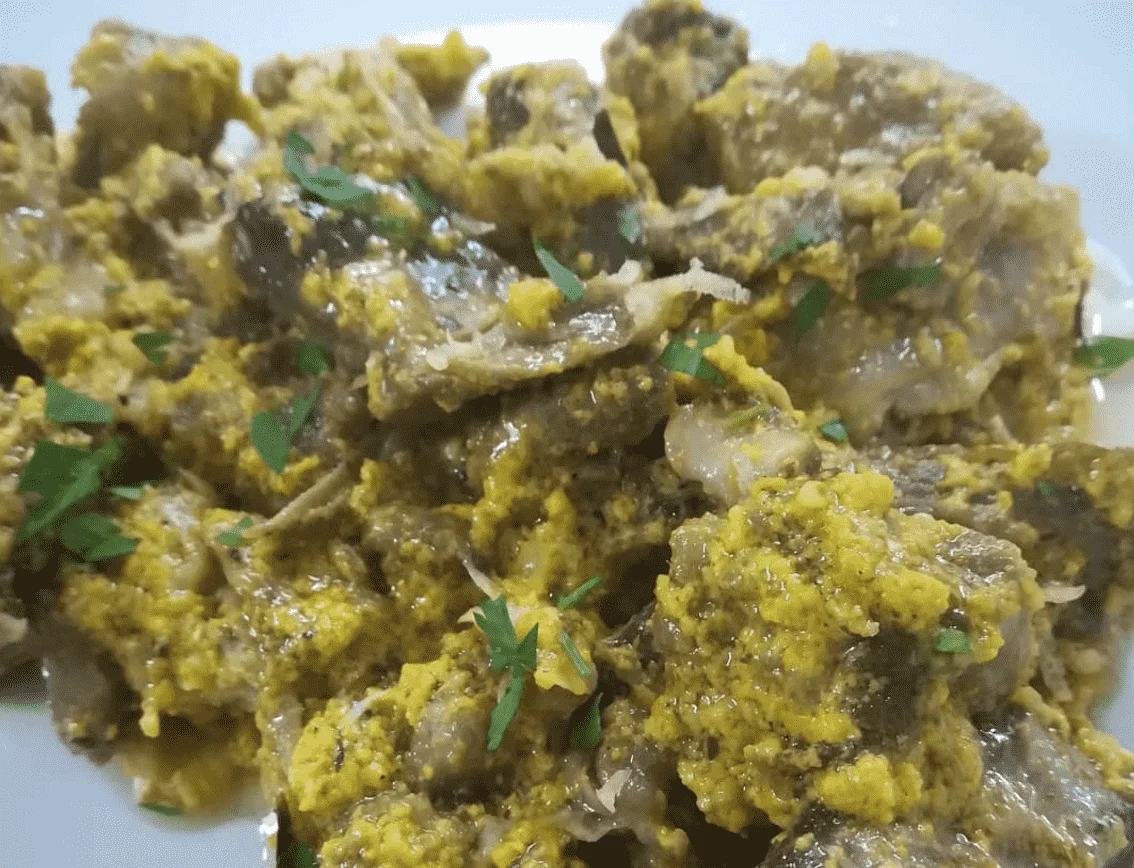 Agnello in fricassea servito con salsa cremosa e prezzemolo fresco