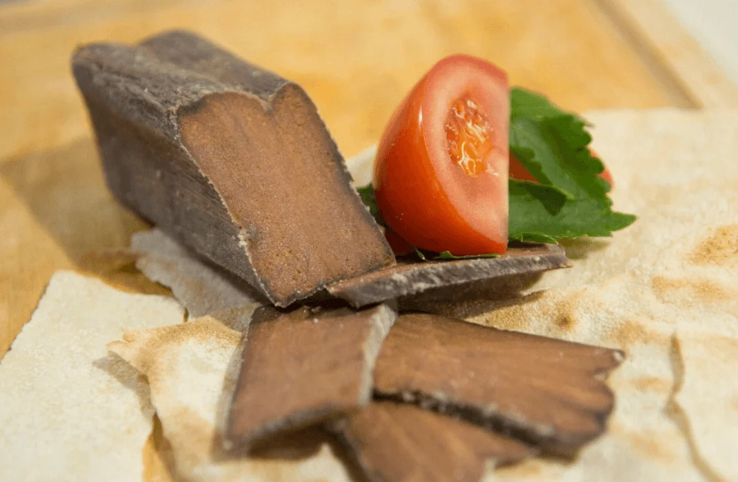 Fettine di bottarga di tonno condite con olio e limone su piatto di ceramica siciliana