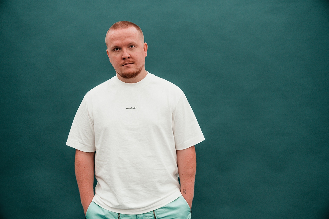 Chris Stussy en una fotografía de prensa con camisa oscura y fondo neutro.