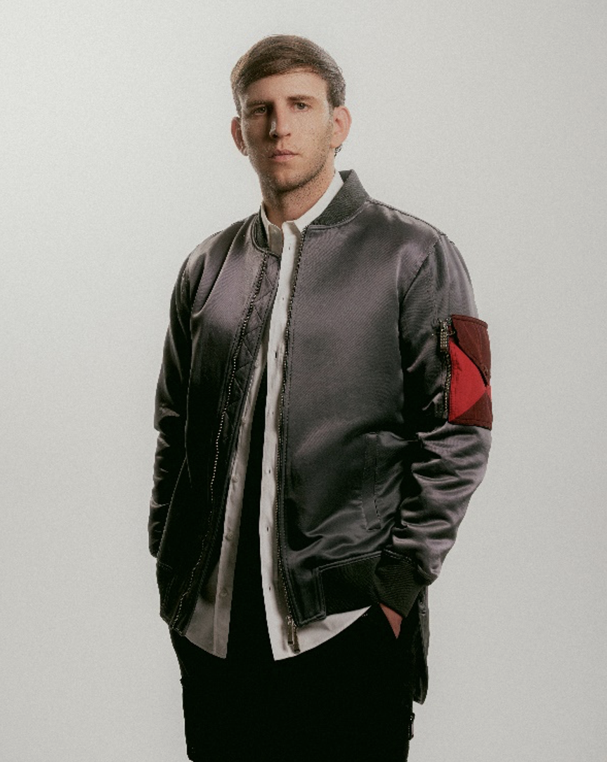 ILLENIUM posa con chaqueta gris en una fotografía de prensa de la etapa ODYSSEY.