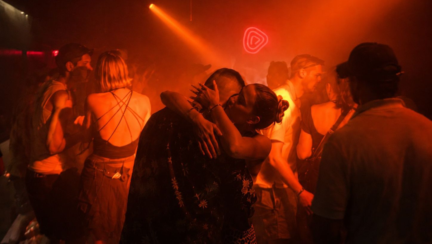 Menschen tanzen unter orangefarbenem Licht auf dem dicht gefüllten Dancefloor des TOLA in Peckham.