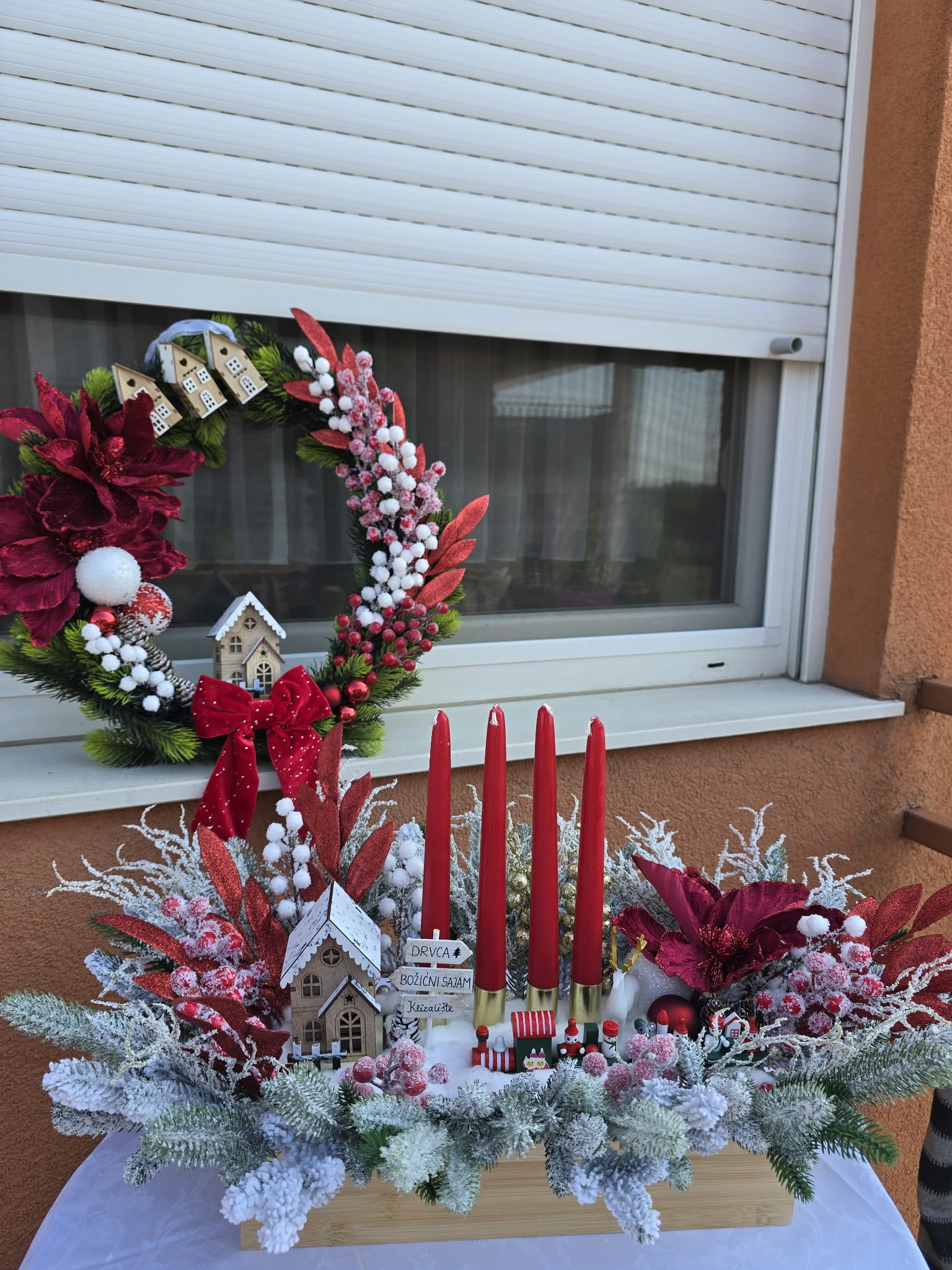 Red advent table wreath with a wooden train and four candles — Atelier Aura